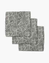 The Rhythm Current Stripes dishcloth set by Sarah Daugherty features three folded rectangular napkins with a black and white geometric pattern, made from recycled materials for a chic, eco-friendly addition to your home.