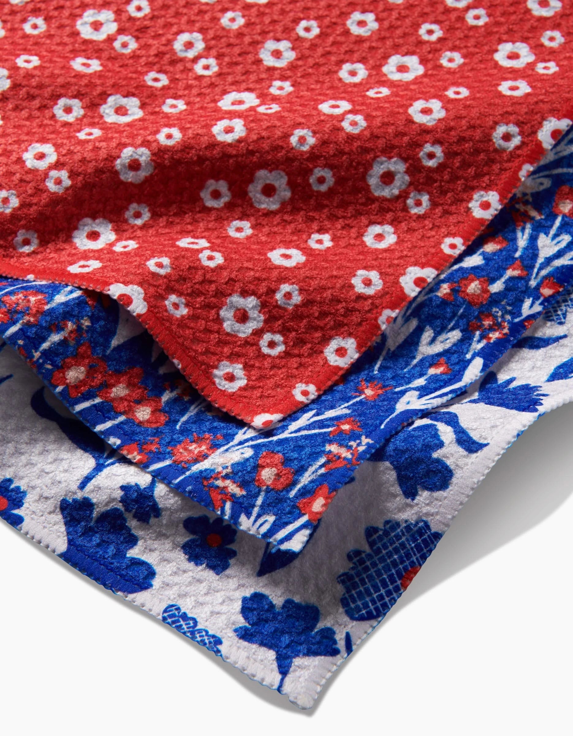 Royal Garden by Danelys Sidron features three layered textured fabrics made from recycled materials: red with white/red flowers on top, blue with red/white flowers in the middle, and white with blue floral and leaf designs at the base.
