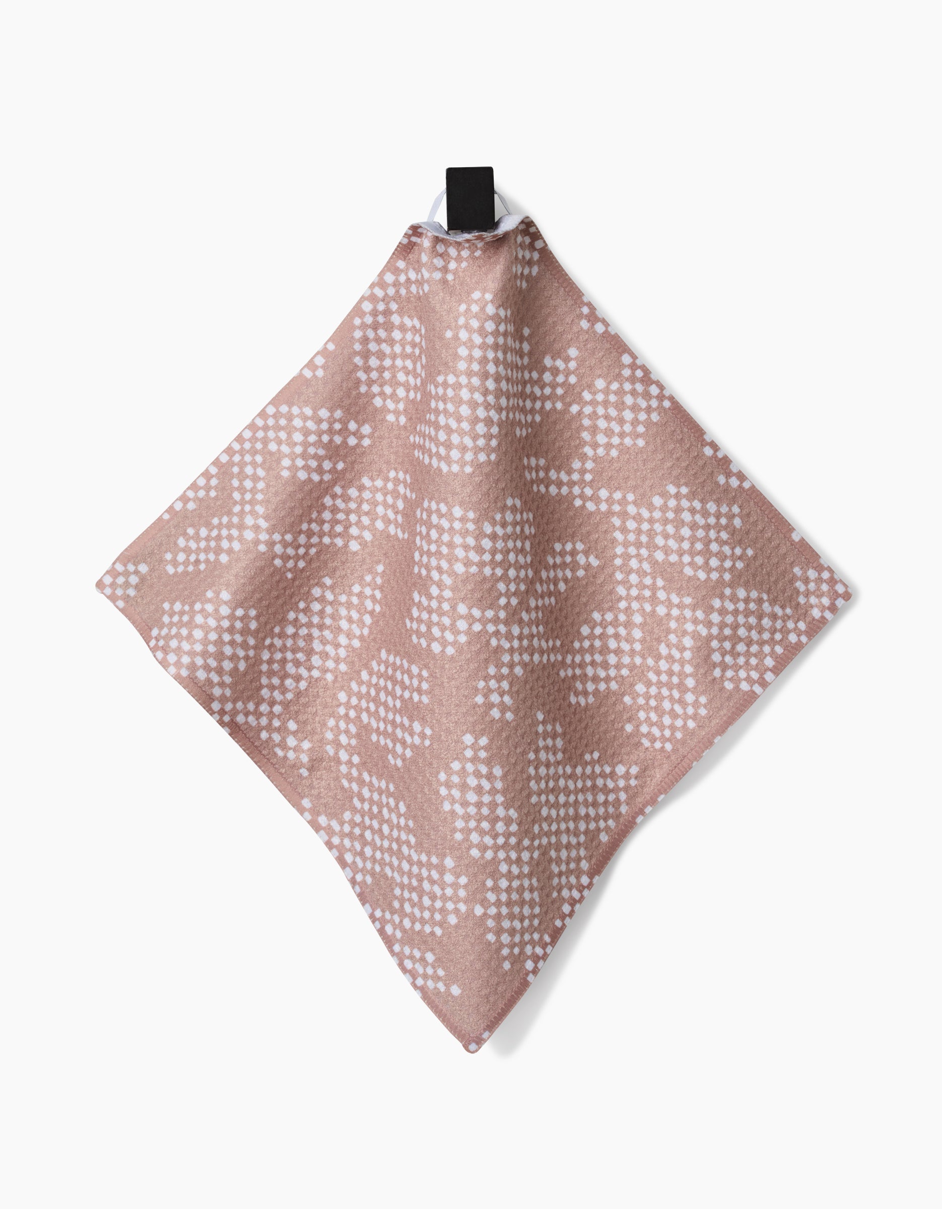 The Studio Jeannot Rubix Pixie is a soft Geoweave fabric dishcloth in muted pink with a white dotted pattern, hanging from a black loop against a plain white background.