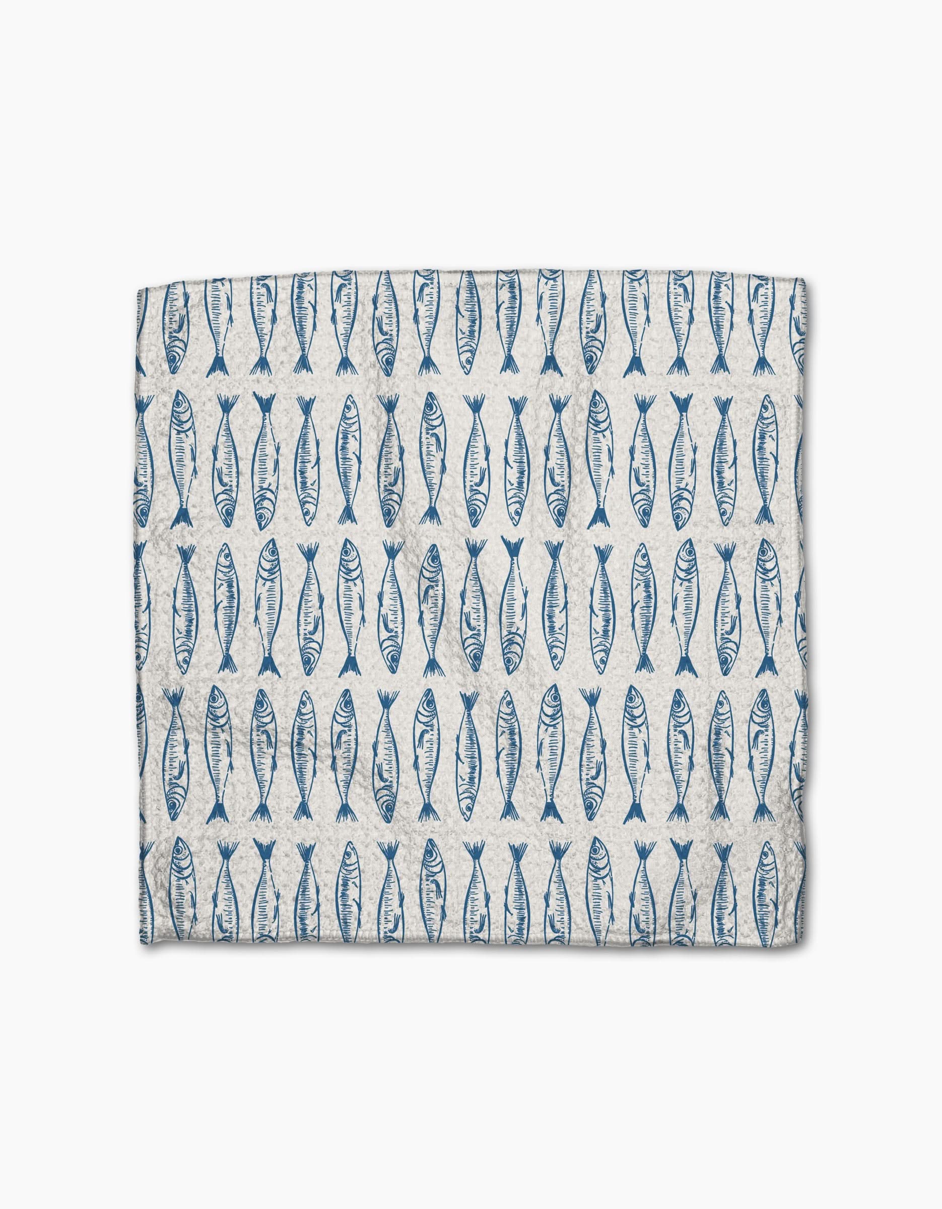 The Sardine Check Blue by Hufton Studio is a rectangular dishcloth featuring blue fish in vertical rows on a light beige Geoweave fabric.