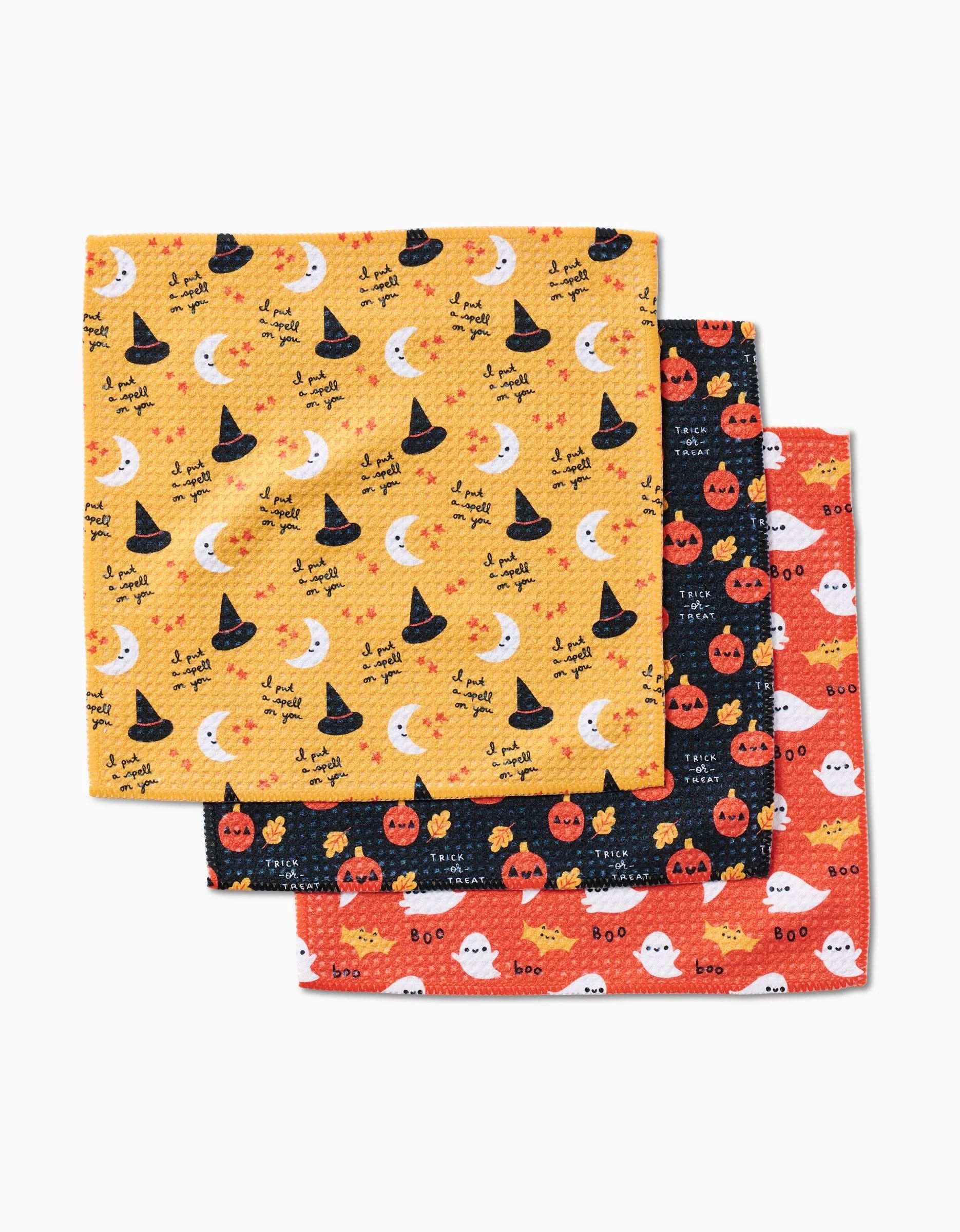 The Genna Blackburn Spooky Season set includes three Halloween-themed dishcloths: yellow with witch hats and text, black with pumpkins, and orange with pumpkins, ghosts, and boo—all made from recycled materials.