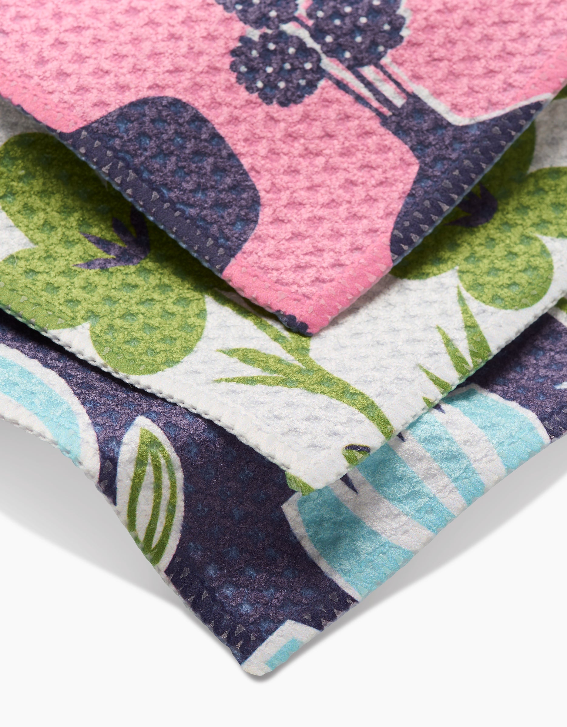 Three super-absorbent Lizzie Clark Spring Bouquet Geoweave dishcloths, featuring colorful plant and vase patterns in pink, green, white, and blue tones, are stacked on a white surface.
