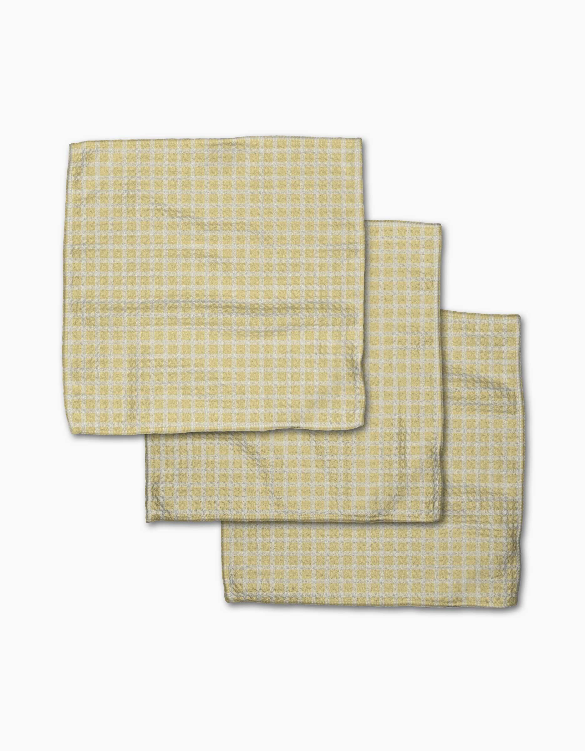 Three Sunspread kitchen towels from GEOMETRY, featuring a yellow and white checkered Geoweave fabric, are partially overlapping each other on a white background.