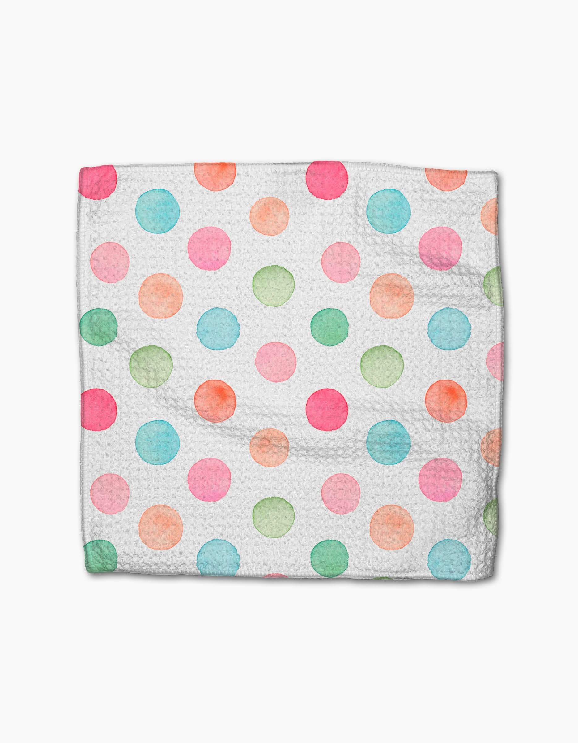 A Sweet Macarons cloth napkin by Elena Fay features a white Geoweave fabric adorned with watercolor polka dots in pink, blue, green, and orange, laid flat on a white background.