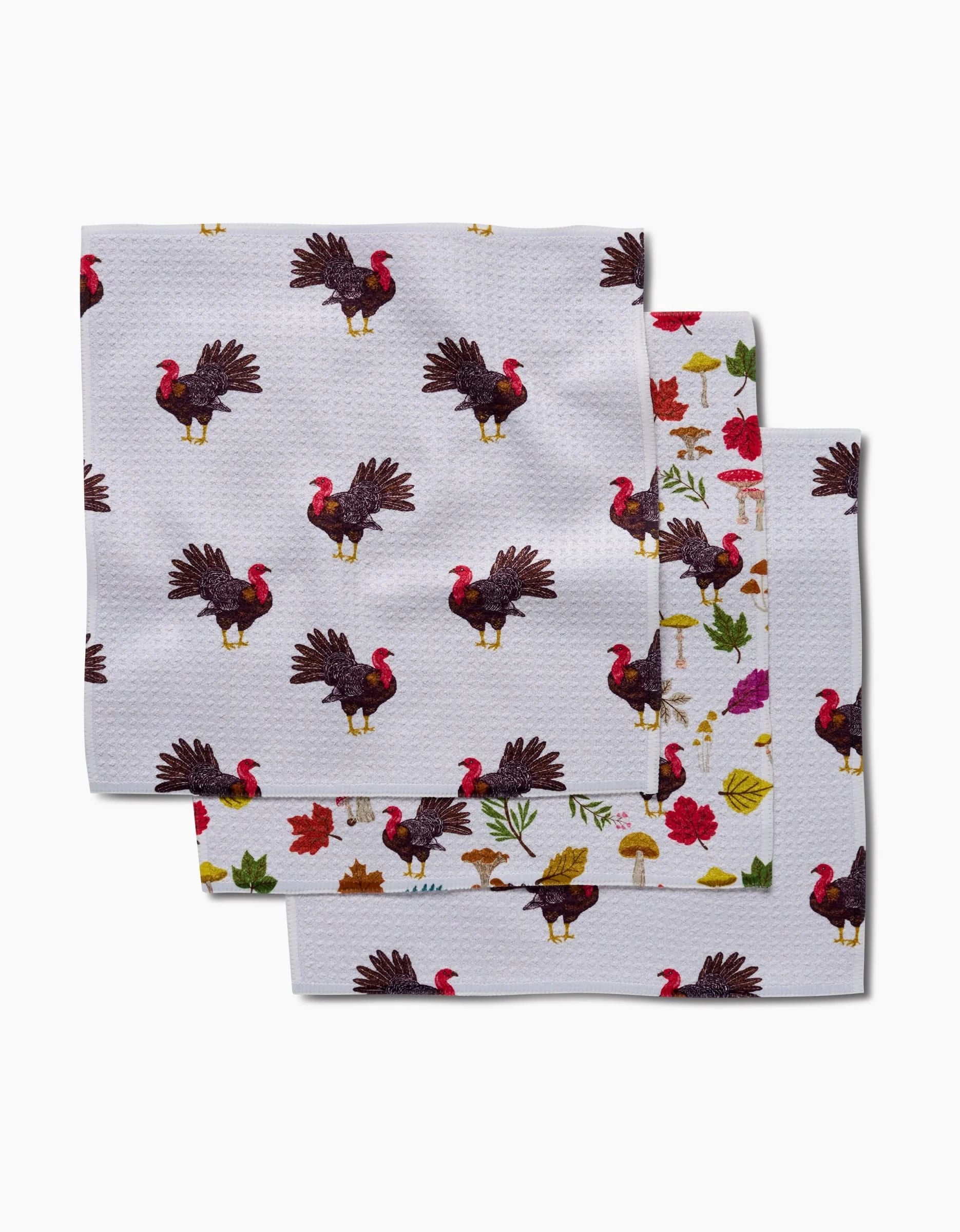 Vaishali Design Studio’s Turkey Day Parade features three eco-friendly napkins with festive Thanksgiving prints—turkeys, leaves, mushrooms, and flowers—on a white background, made from recycled materials.