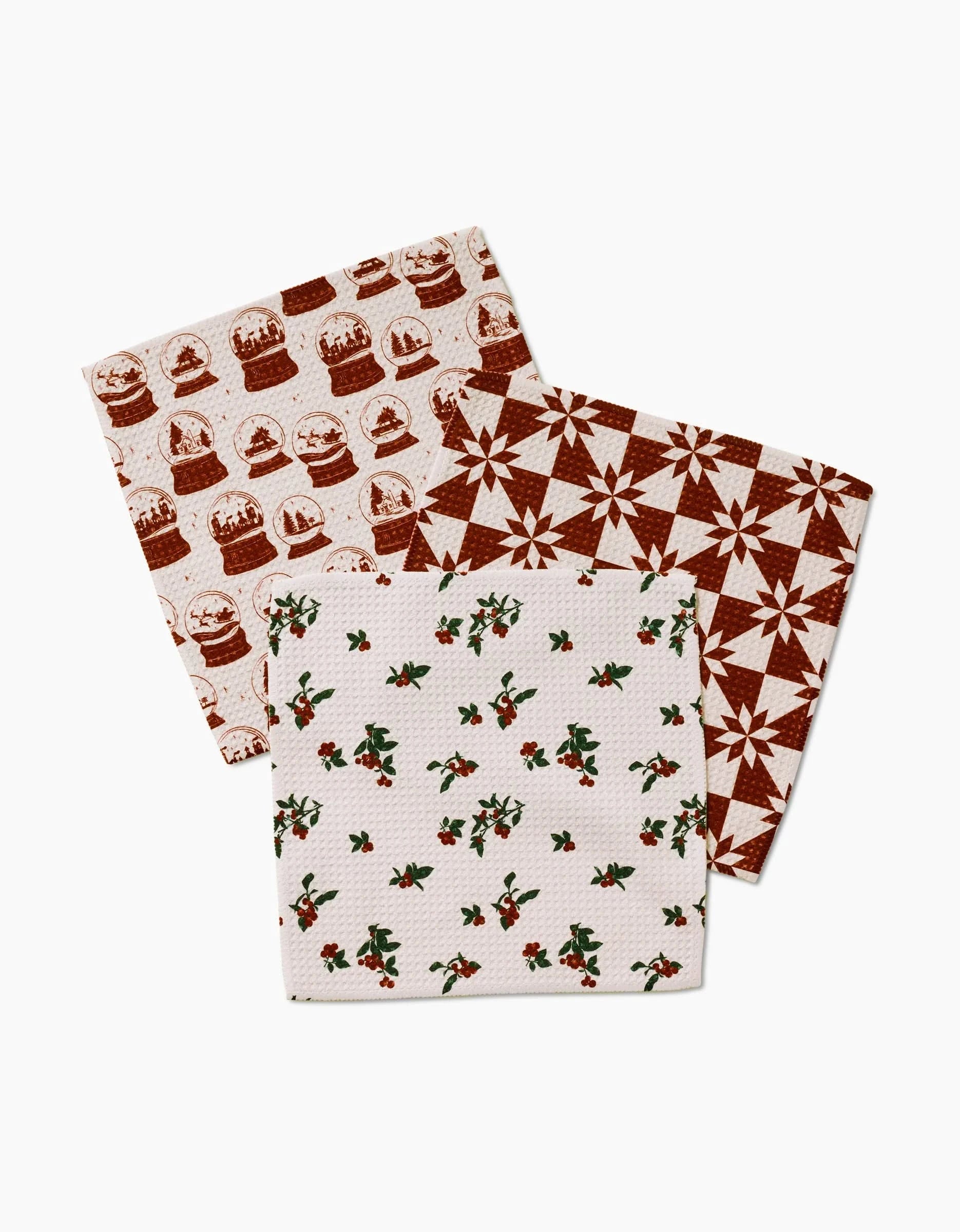 Three folded Aubrey Fairchild Vintage Christmas Geoweave dishcloths with holiday-themed patterns are arranged on a white background.