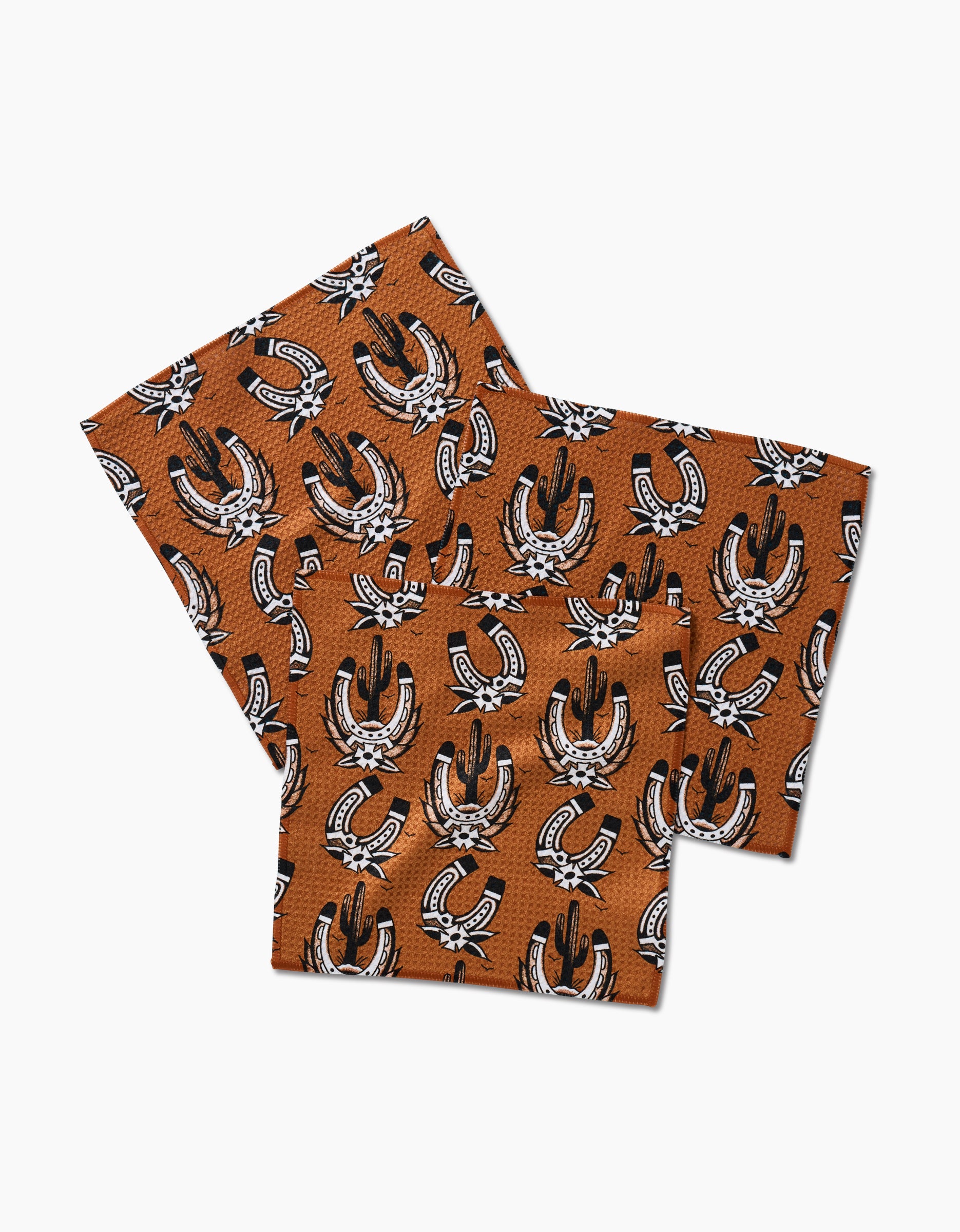 The Western Horseshoes napkins by Cole Strem are brown, made from recycled materials, and feature a black and white horseshoe and cowboy boot pattern on a white background.