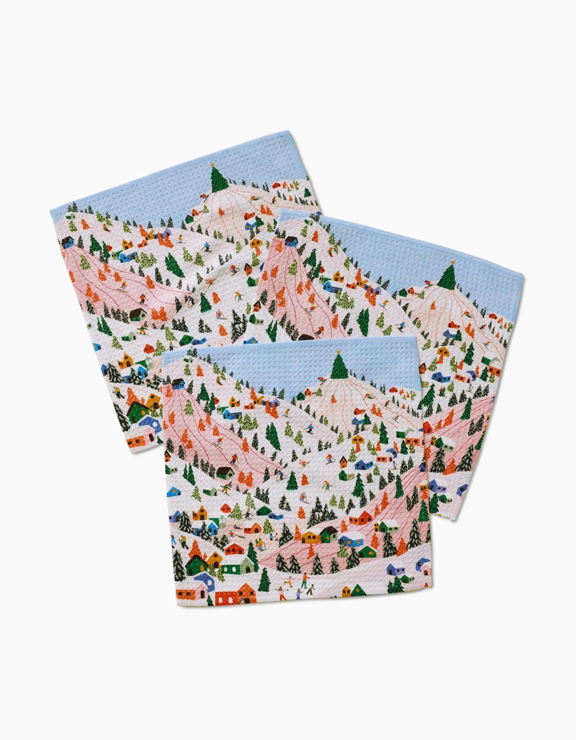 The Winter Holiday dishcloth set by Ceyda Alasar includes three recycled cloths featuring a playful, colorful winter mountain scene with snowy peaks, skiers, trees, and cabins on a white background.