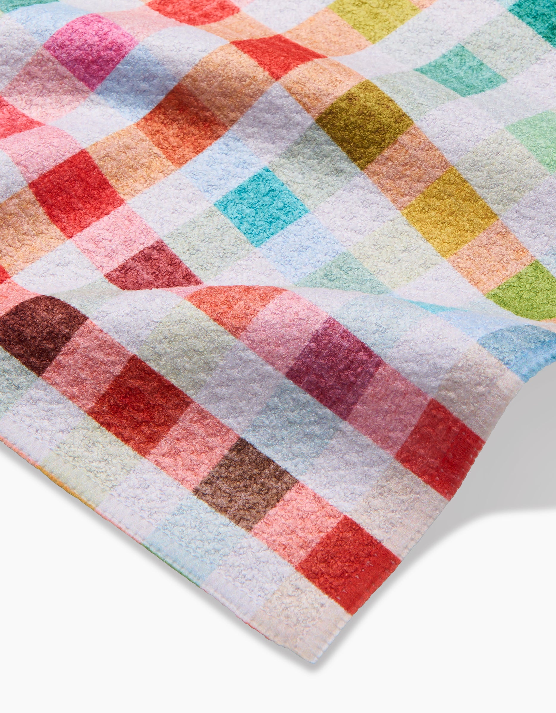 A close-up of the Pascale Dilger Woven Spring Plaid dishcloth, showing its colorful plaid pattern on white Geoweave fabric, designed for enhanced absorbency.