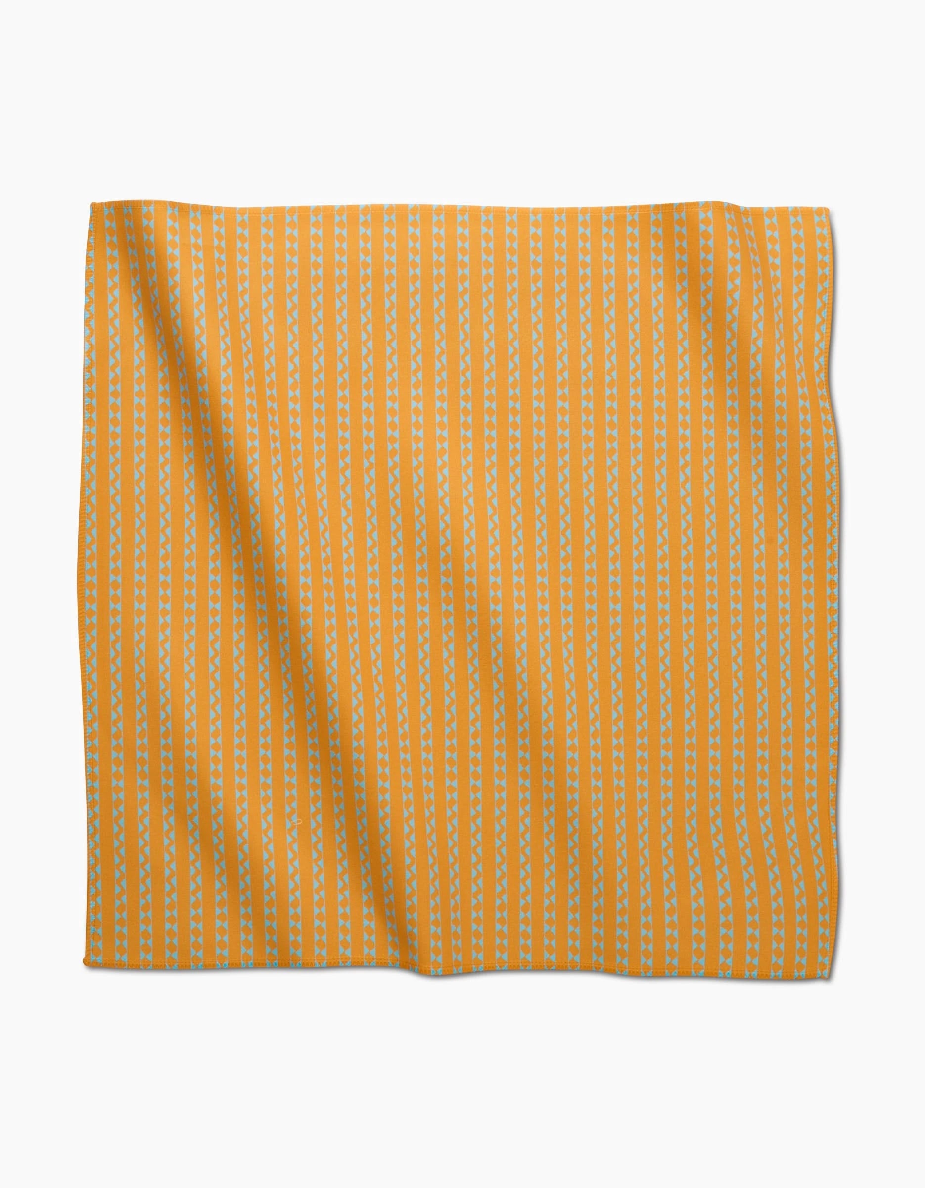 The Castillo by GEOMETRY features orange Geosuede fabric with vertical rows of small white triangles in a repeating pattern, perfect for eco-friendly, stylish dinner napkins crafted from recycled materials.