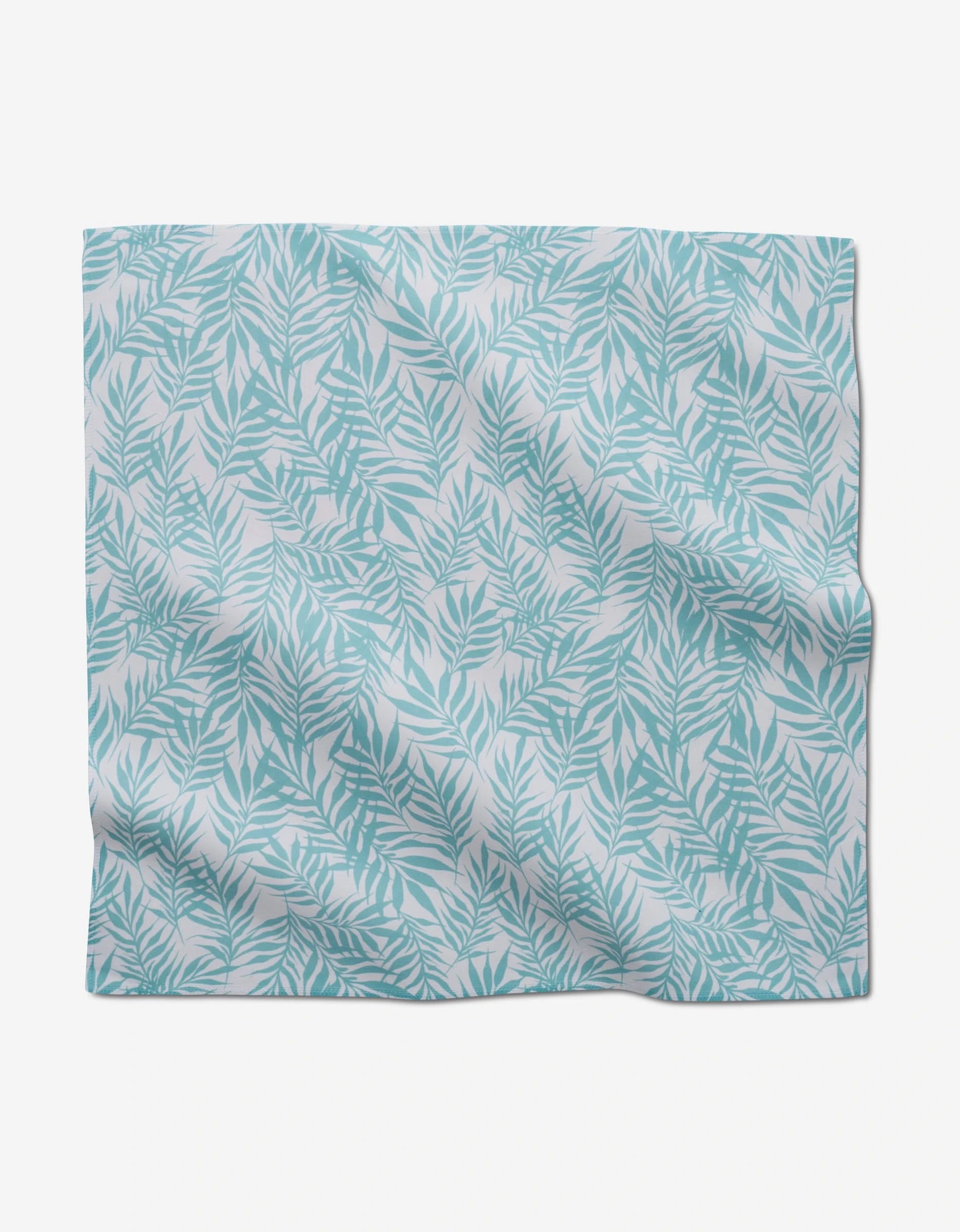 Aqua Branches by GEOMETRY features a light blue leafy pattern on white, shown flat with slight wrinkles—ideal for reusable or eco-friendly dinner napkin sets.