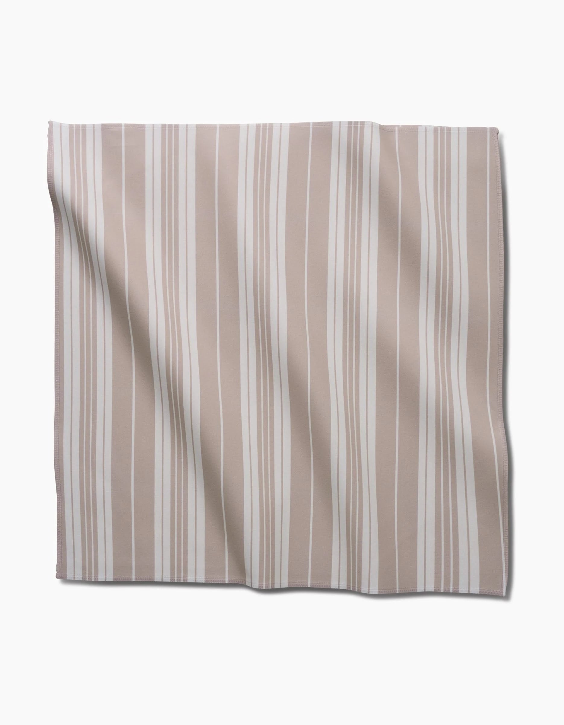 The GEOMETRY Betty Beach Dinner Napkin Set, made from Geosuede fabric with beige and white vertical stripes, is laid flat on a white background, showing soft folds and slight wrinkles.