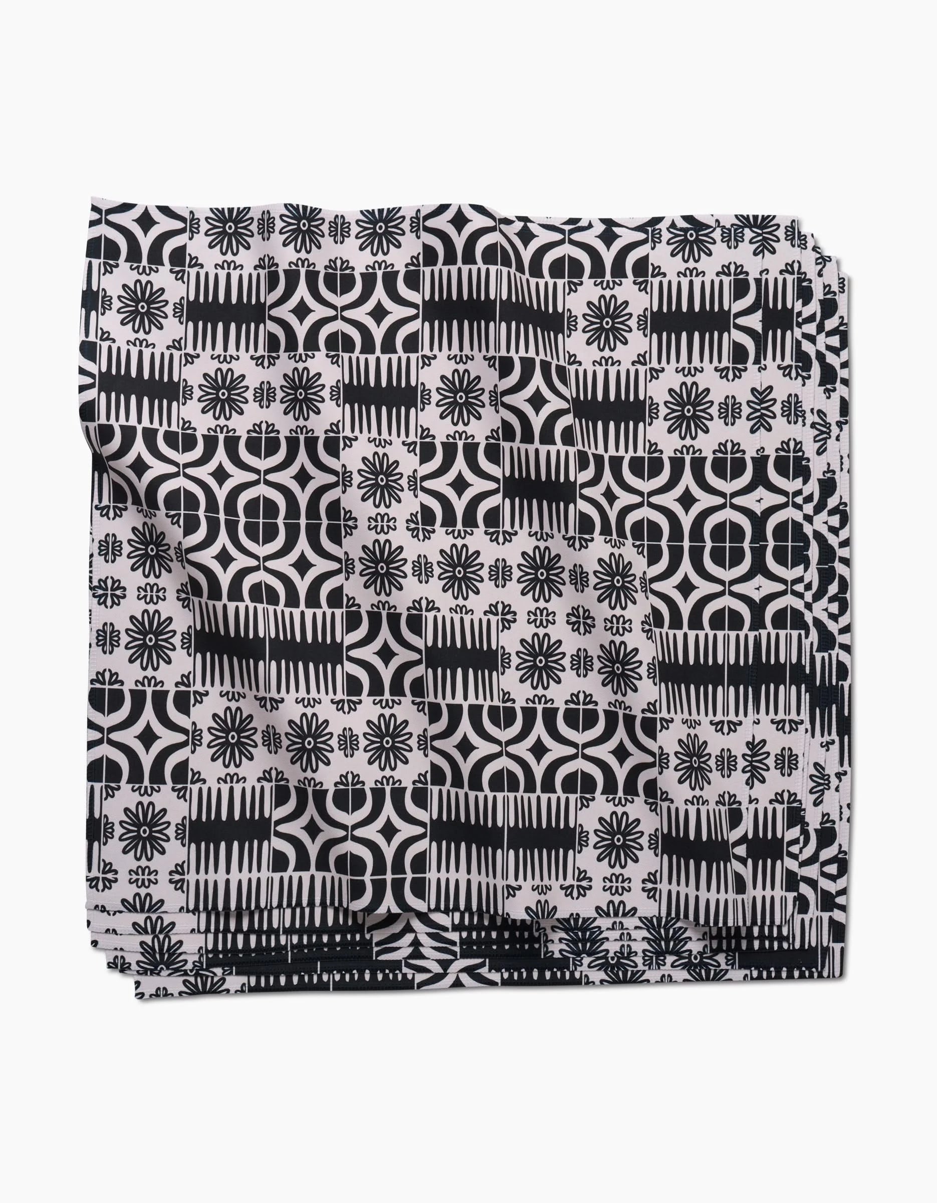 The GEOMETRY Bohemian Mosaic dinner napkin set features Geosuede fabric with a black and white geometric and floral pattern of circles, lines, and flower-like shapes on a white background.
