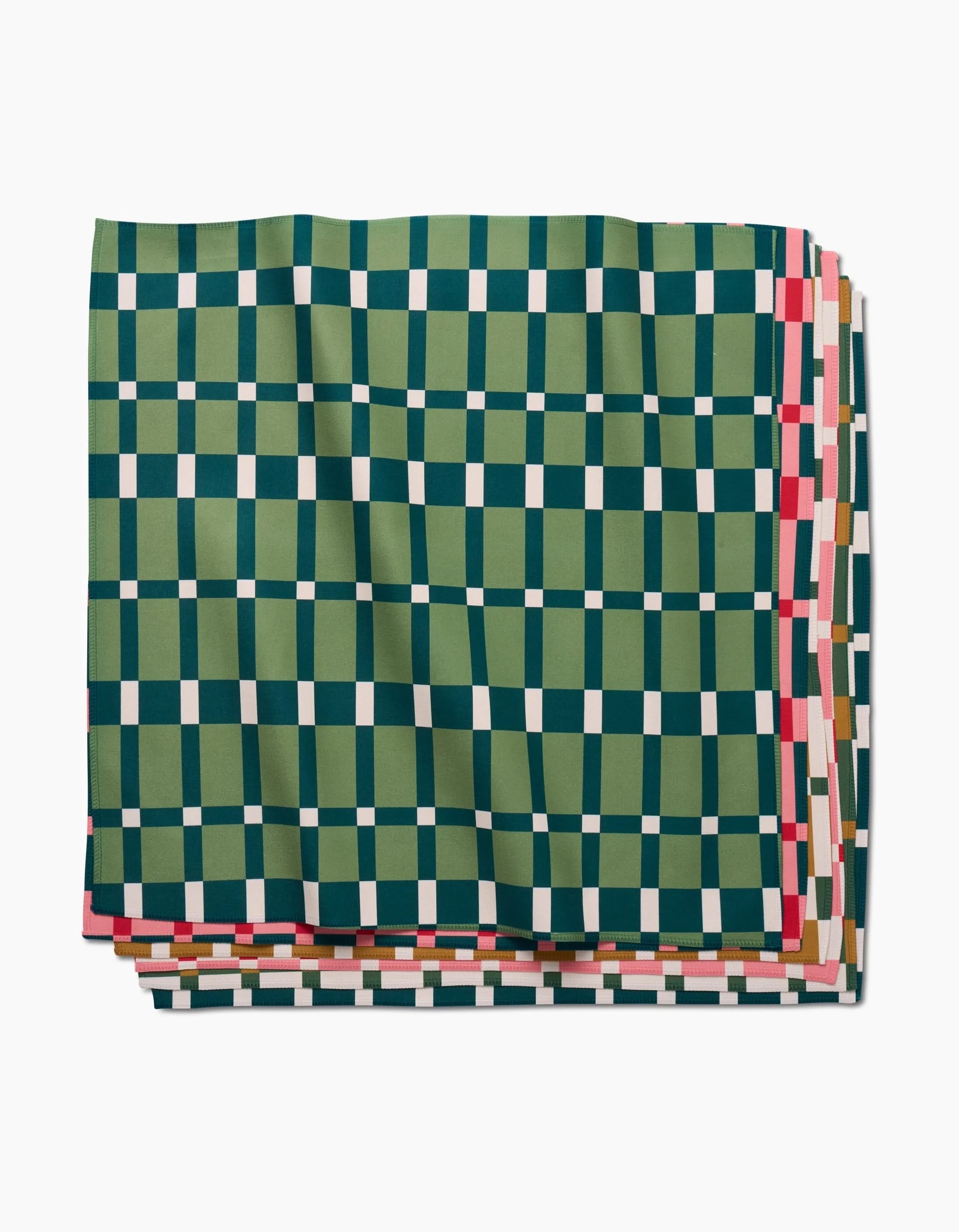 Rebecca Woolbrights Candy Plaid recycled dinner napkins feature a vibrant green, navy blue, and white checkered design with accents of pink, red, and tan edges, displayed on a white background.
