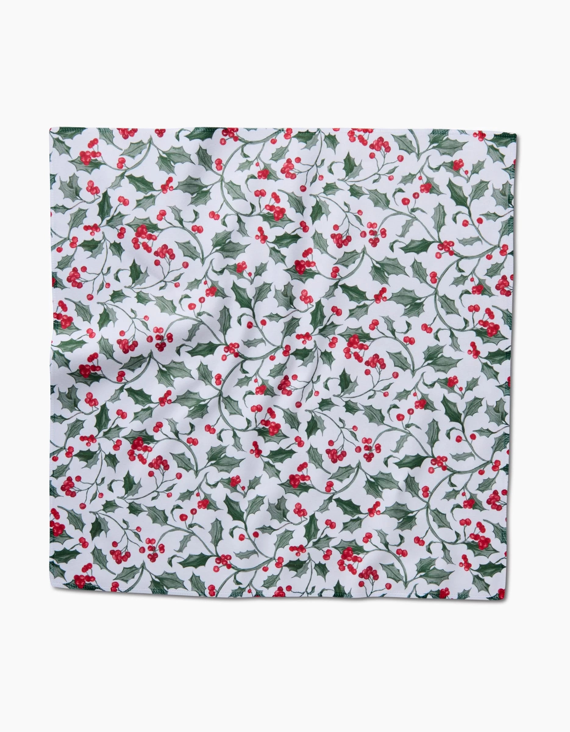 The Aubrey Fairchild Christmas Holly napkin is a square, absorbent cloth featuring green holly leaves and red berries on a white background.