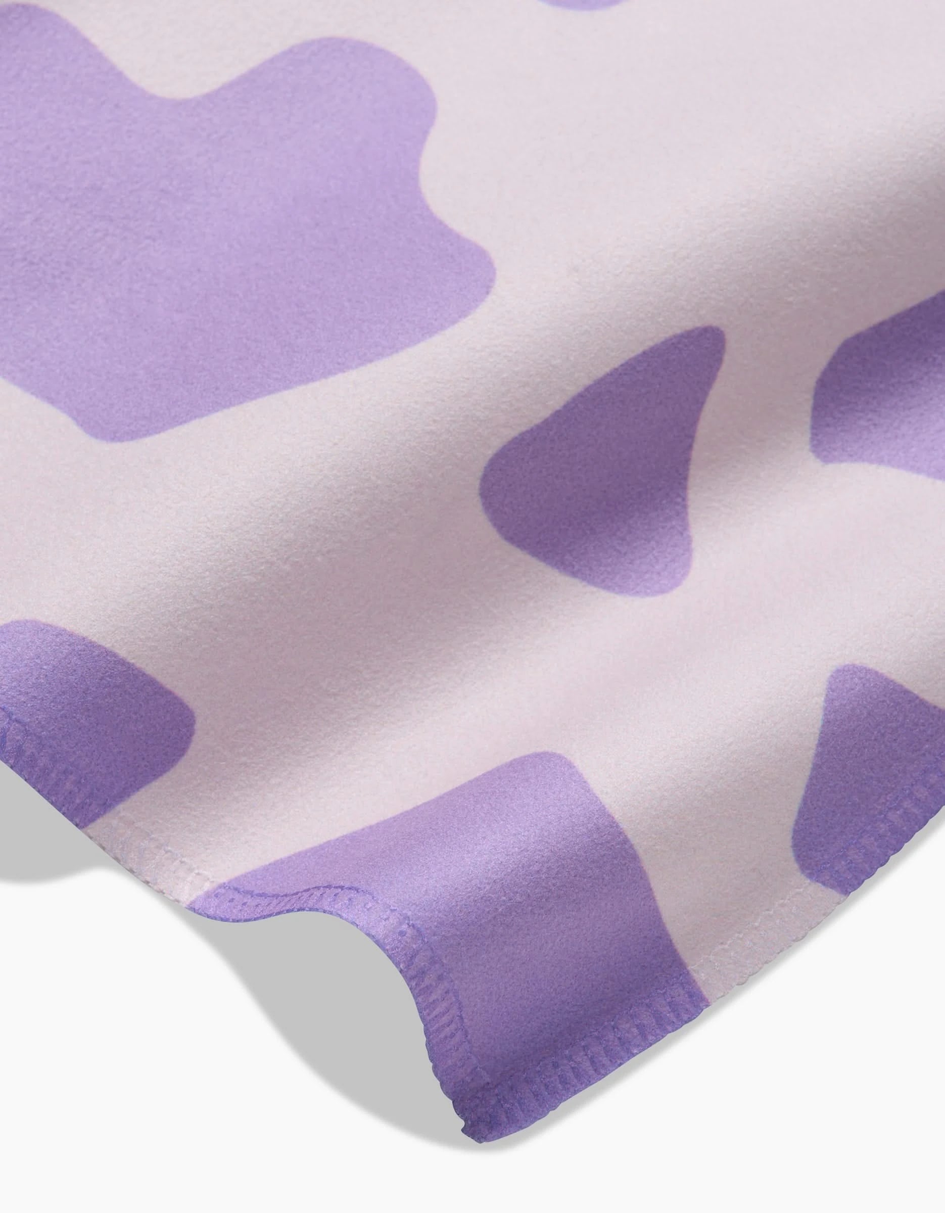 The GEOMETRY Cow Print Lilac is a soft, absorbent napkin with a lilac base and cow-print spots, neatly stitched edges, and perfect as an eco-friendly dinner napkin.