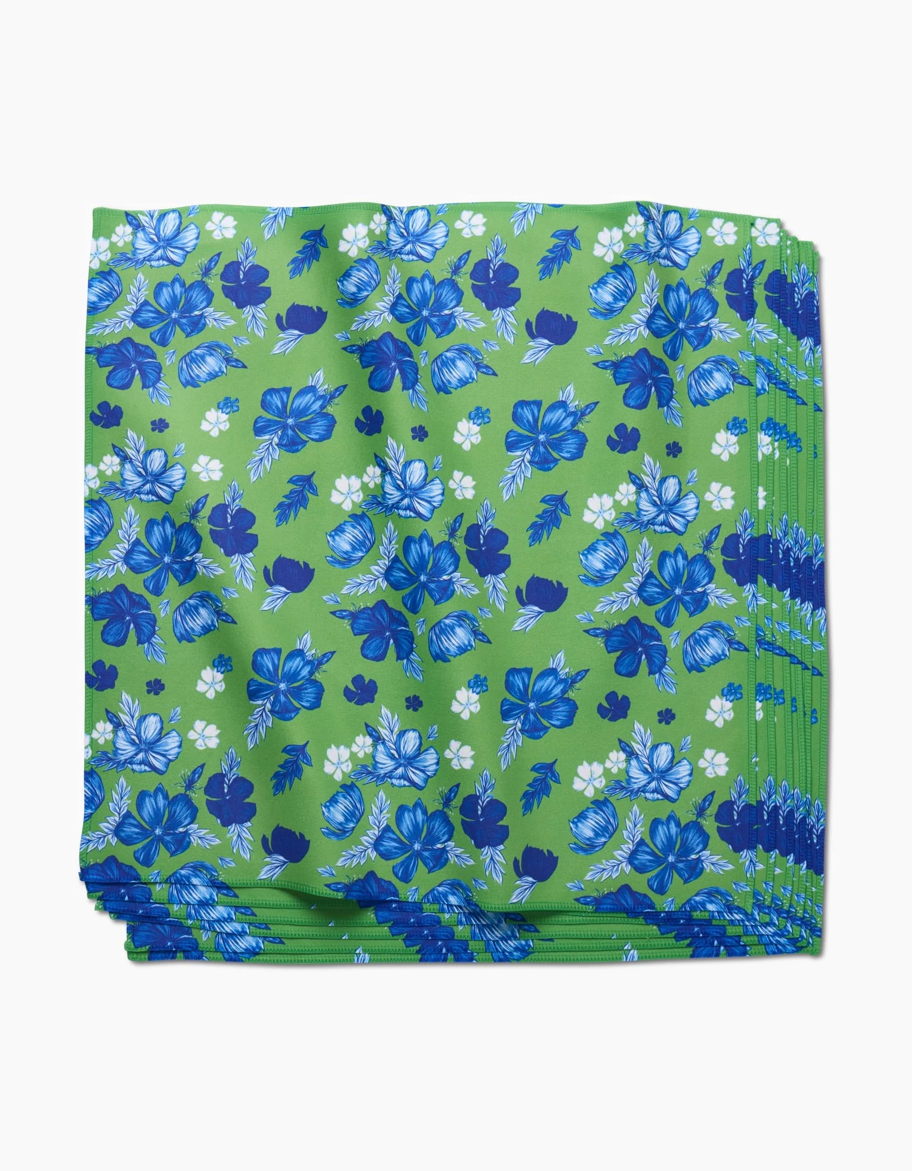 The Flower Bomb Dinner Napkin Set by GEOMETRY features folded green Geosuede fabric with a blue and white floral pattern, crafted from recycled materials for an eco-friendly and stylish table setting.