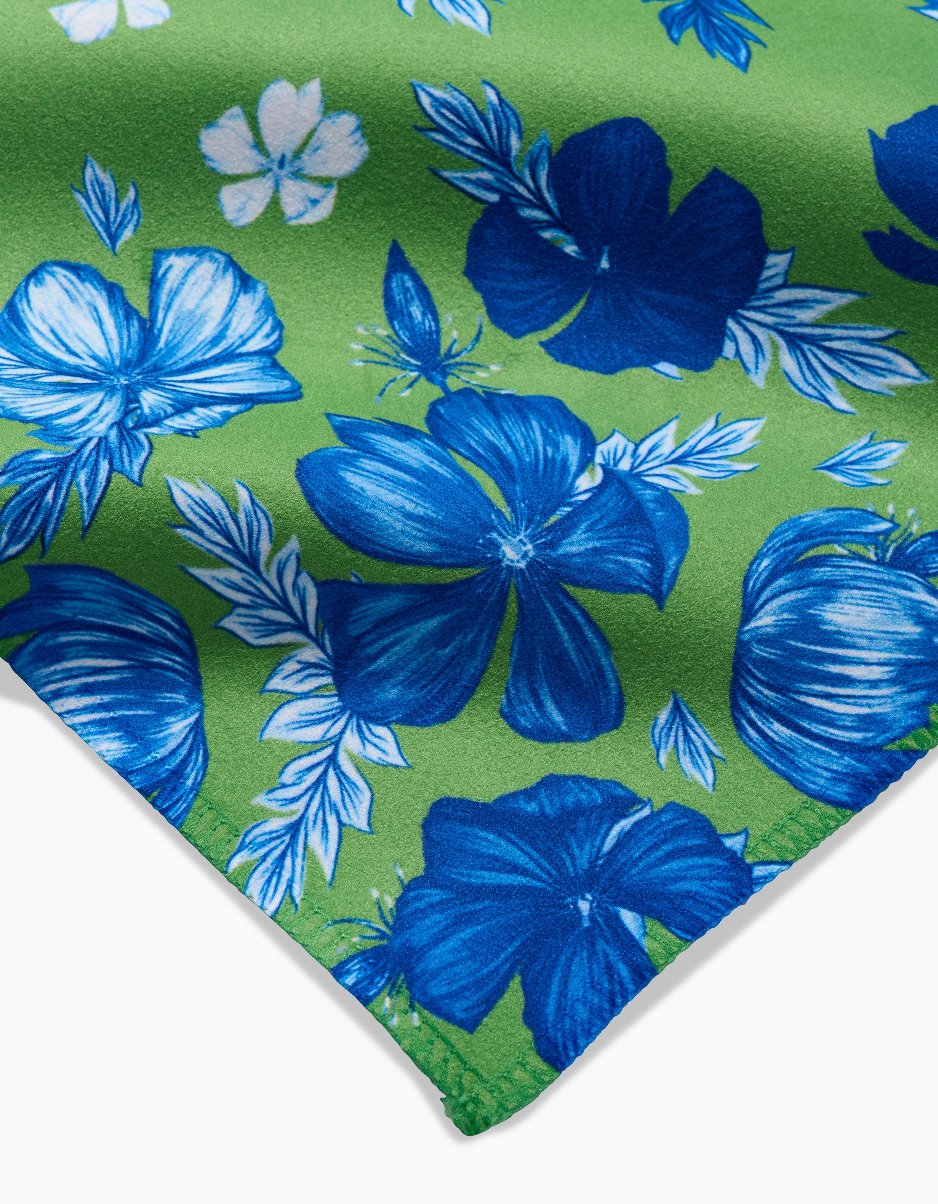 A close-up of GEOMETRYs Flower Bomb, featuring green Geosuede fabric with a blue and white hibiscus print and leafy patterns—an eco-friendly material made from recycled materials.