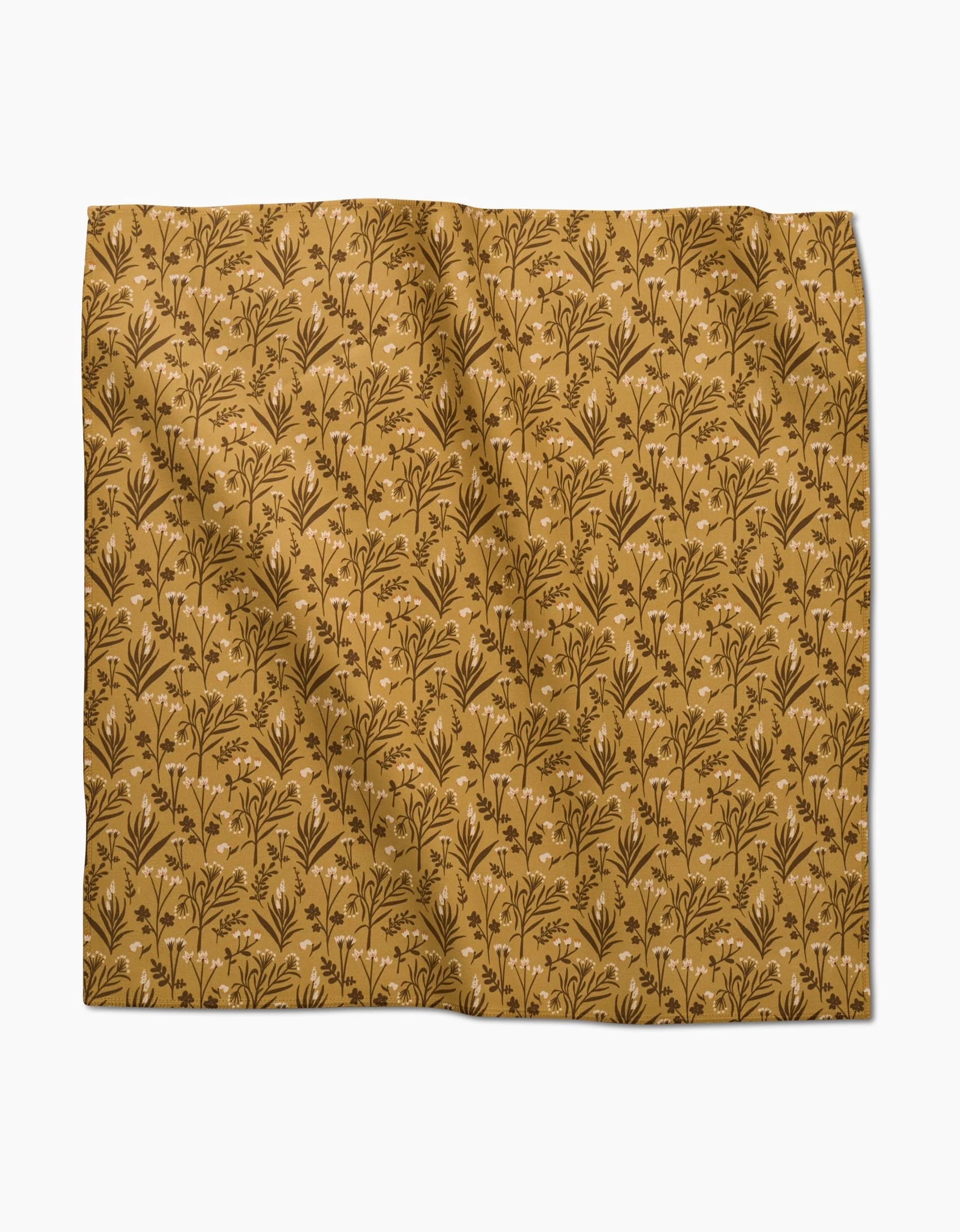 The Golden Fall Flowers napkin set by Danelys Sidron features a mustard yellow background with brown botanical patterns. This eco-friendly set adds charm to any table, and the slightly wrinkled fabric enhances its natural appeal.
