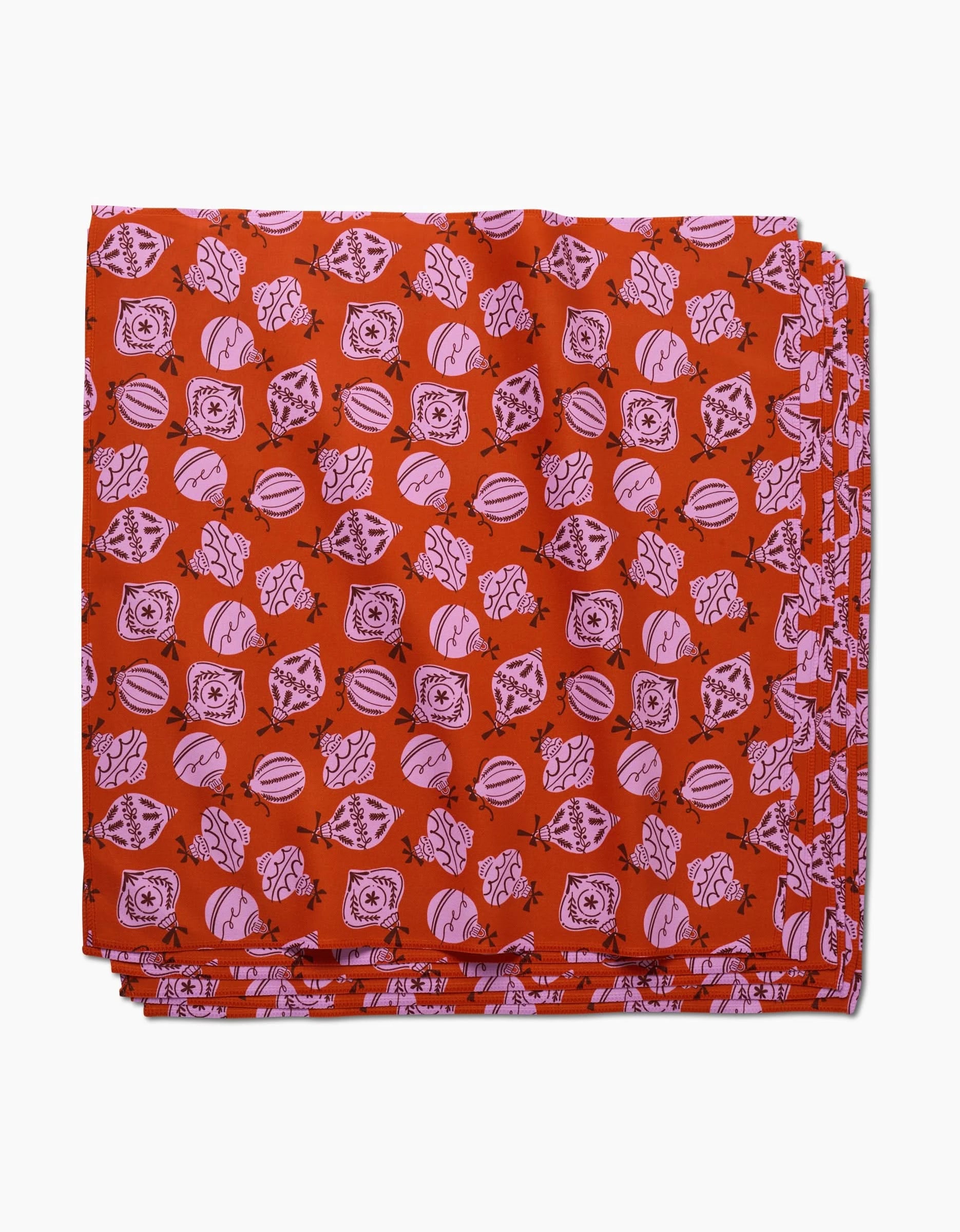A stack of Grans Ornaments red reusable cloth napkins by Charlie Rowan Designs features pink and black geometric and organic patterns, displayed on a white background.