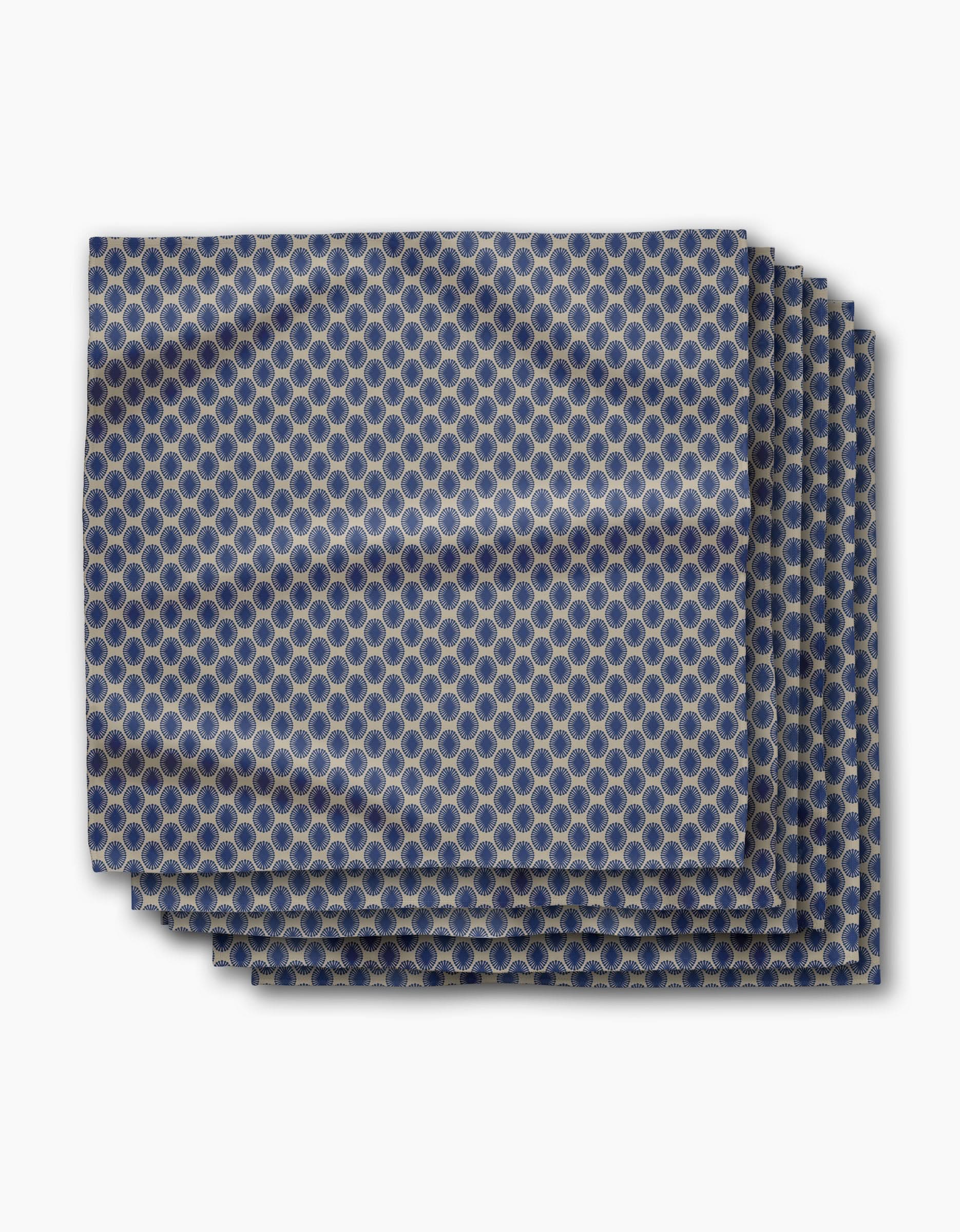 The Lagoon pocket square by Geometry features a blue and gold repeating circular geometric pattern, neatly folded and displayed on a white background.