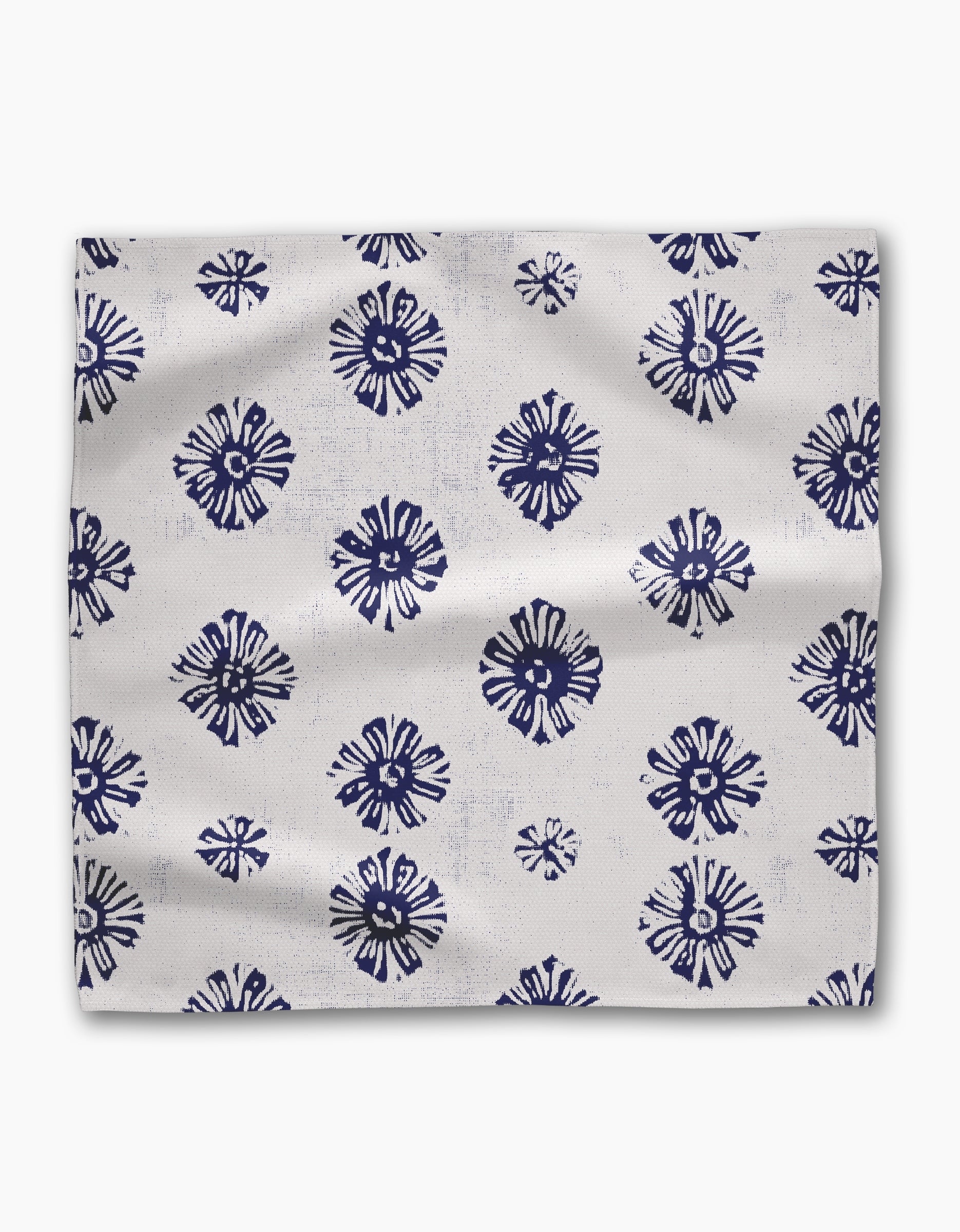 Leyla White by Geometry features Geosuede fabric with a white base and evenly spaced navy blue, abstract floral or sunburst patterns—ideal for a stylish Dinner Napkin Set.