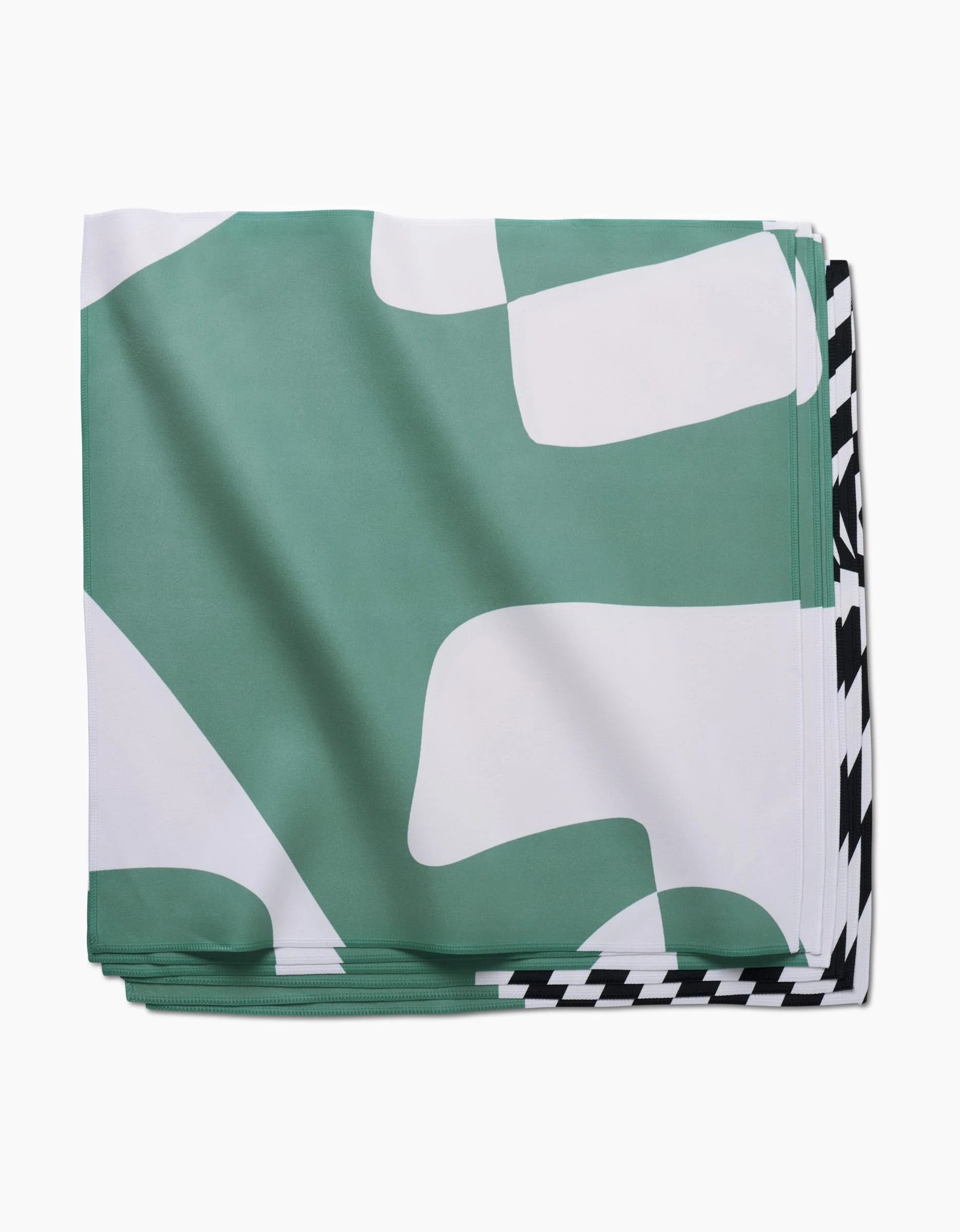 The Mint Stripes dinner napkin by GEOMETRY features a green and white abstract pattern with a black and white houndstooth edge. Made from recycled Geosuede fabric for sustainable style.
