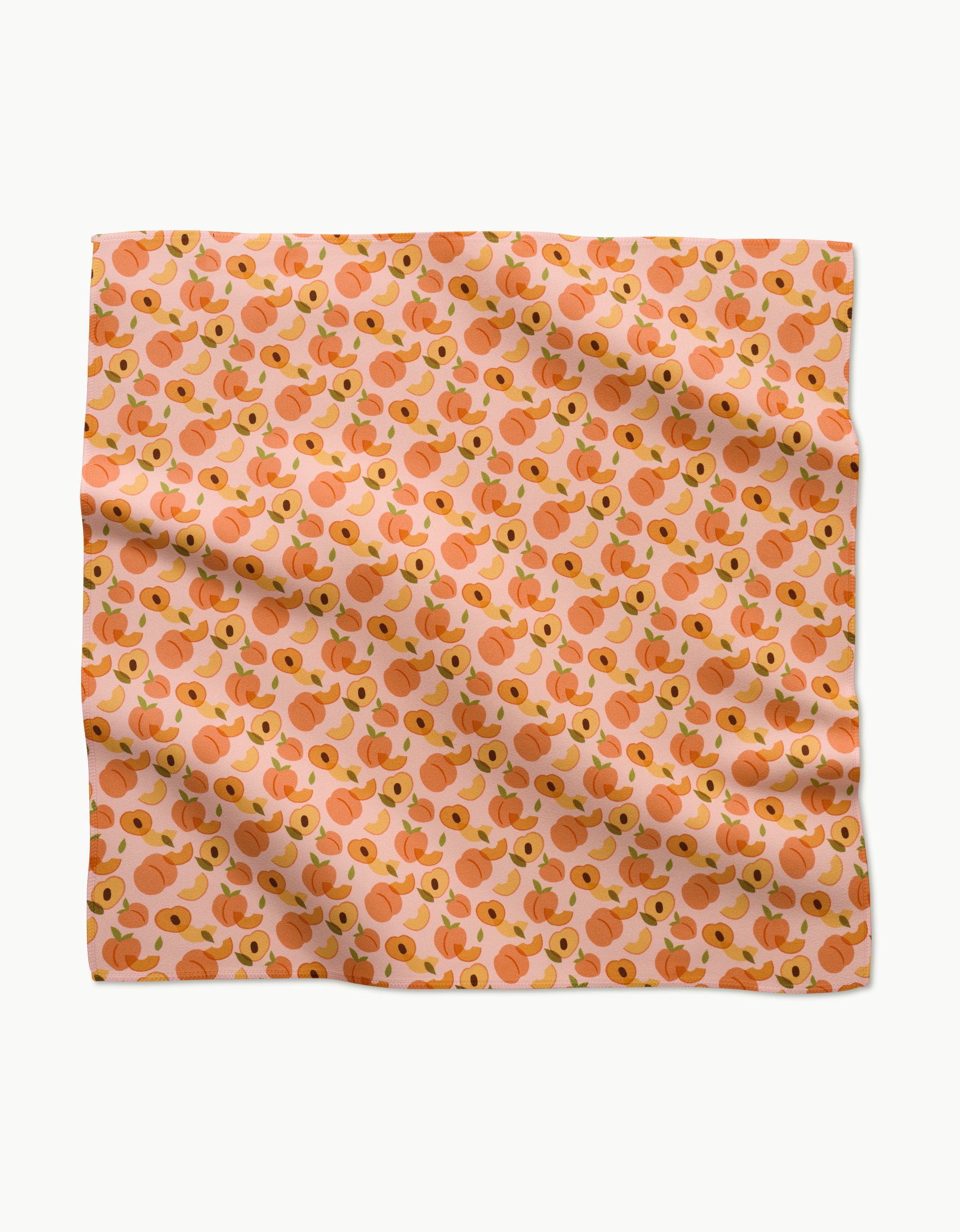 The GEOMETRY Peaches scarf features a peach-colored background with a repeating illustrated peach and green leaf pattern. Made from recycled materials, the slightly wrinkled fabric is shown flat on a white surface.