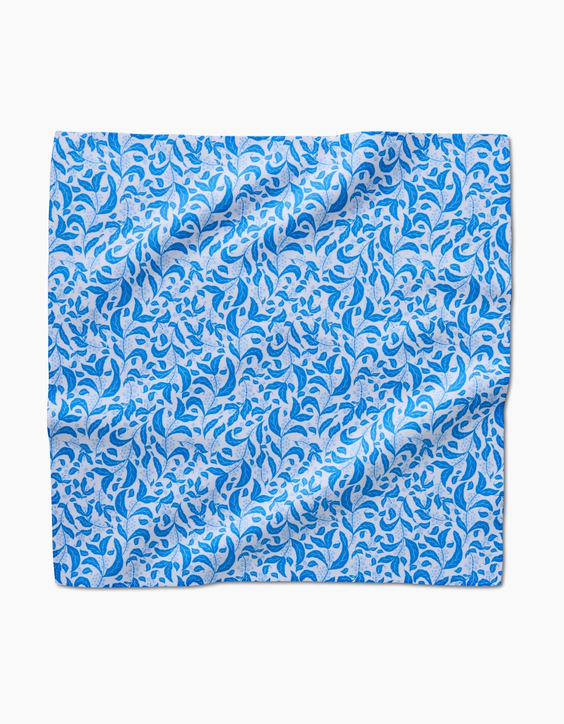 The Danelys Sidron Snowberry set includes square, absorbent dinner napkins with a blue and light blue floral and leaf design on white, slightly wrinkled and lying flat.