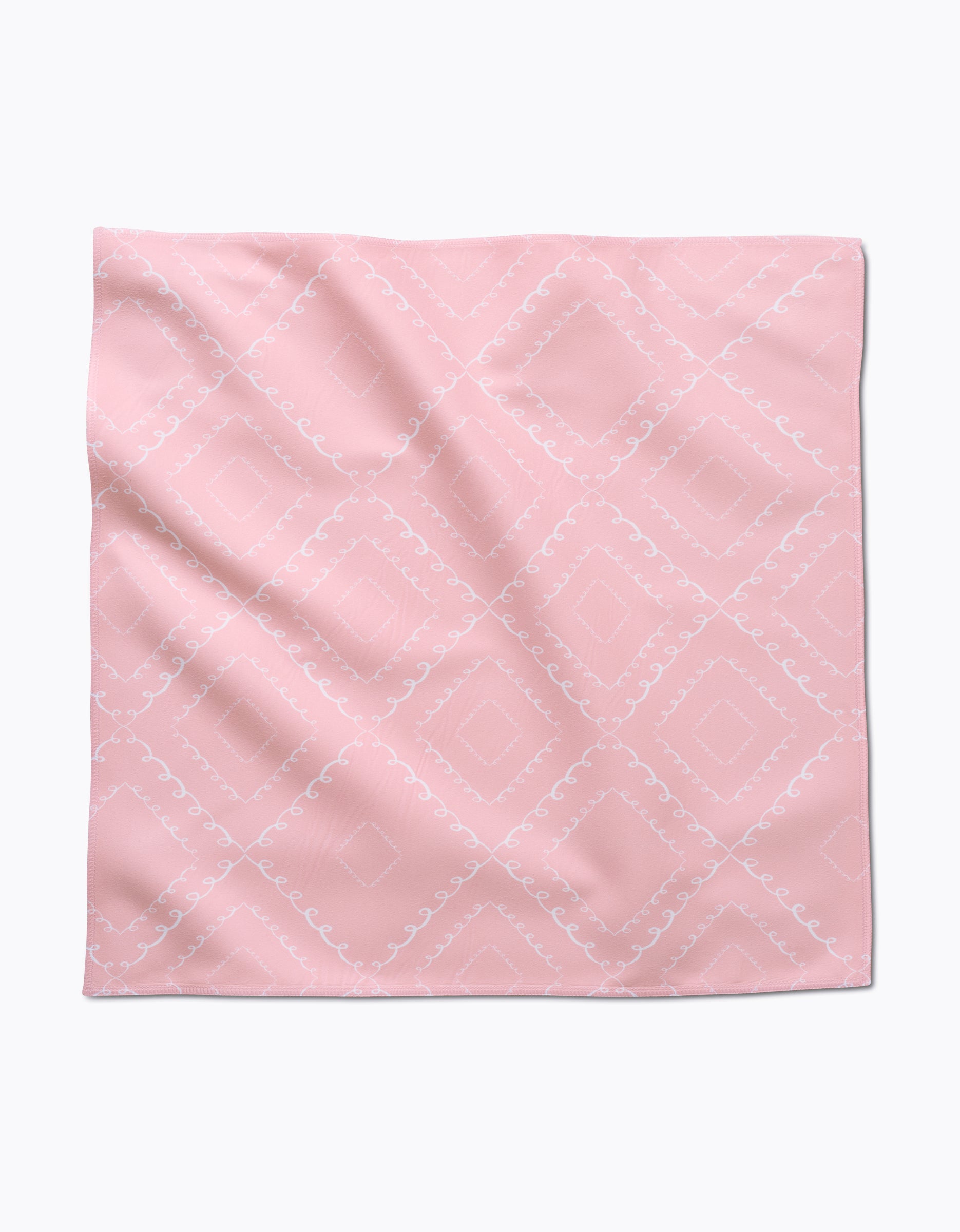 The Elena Fay Twirls is a square, light pink cloth napkin featuring a subtle white diamond and swirl pattern, shown laid flat with slight wrinkles.
