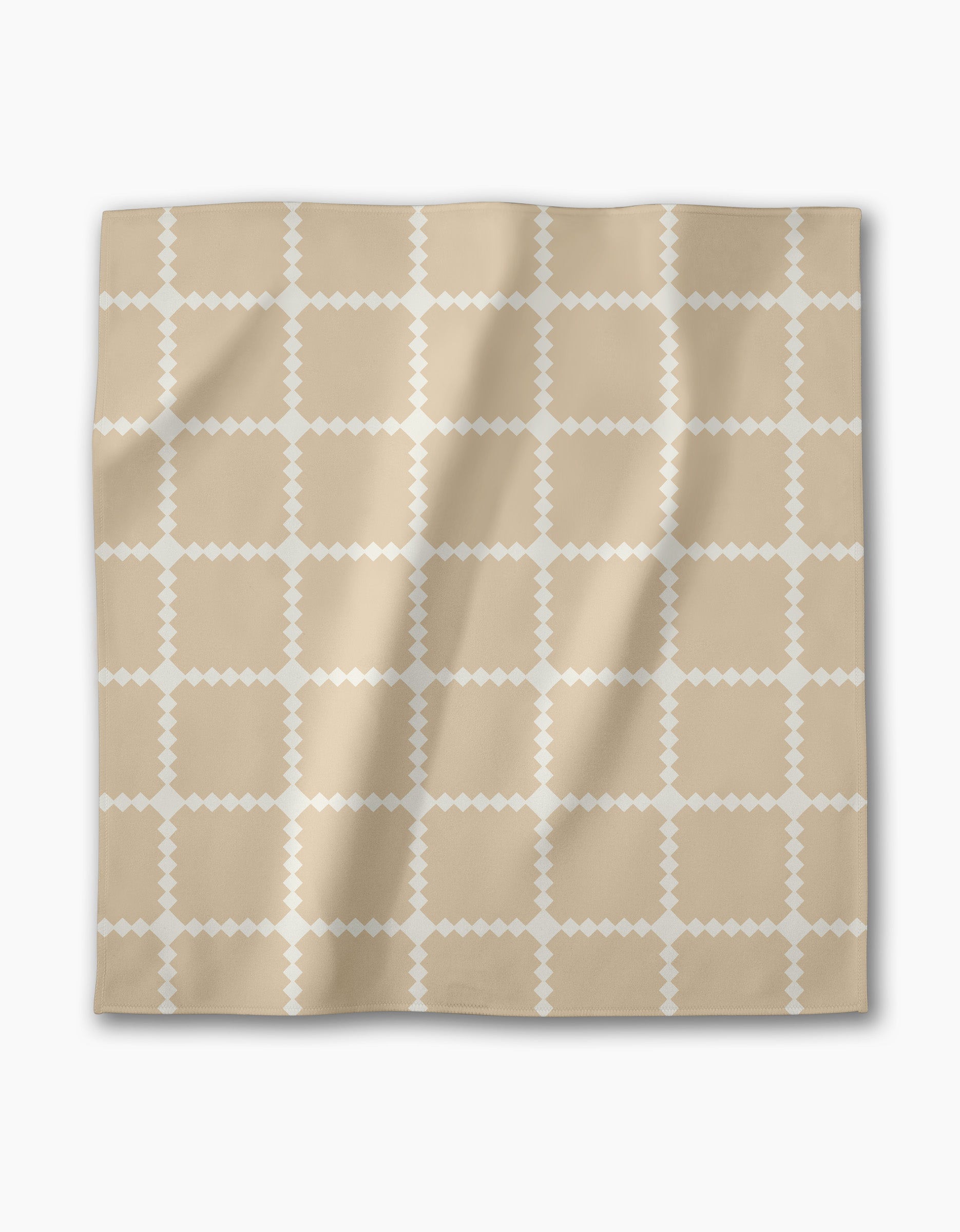 The Valencia Tile by Danelys Sidron is a beige square scarf featuring a white diamond-shaped grid pattern. Displayed flat on a white background, its soft texture and gentle folds evoke the elegance of a fine reusable dinner napkin set.