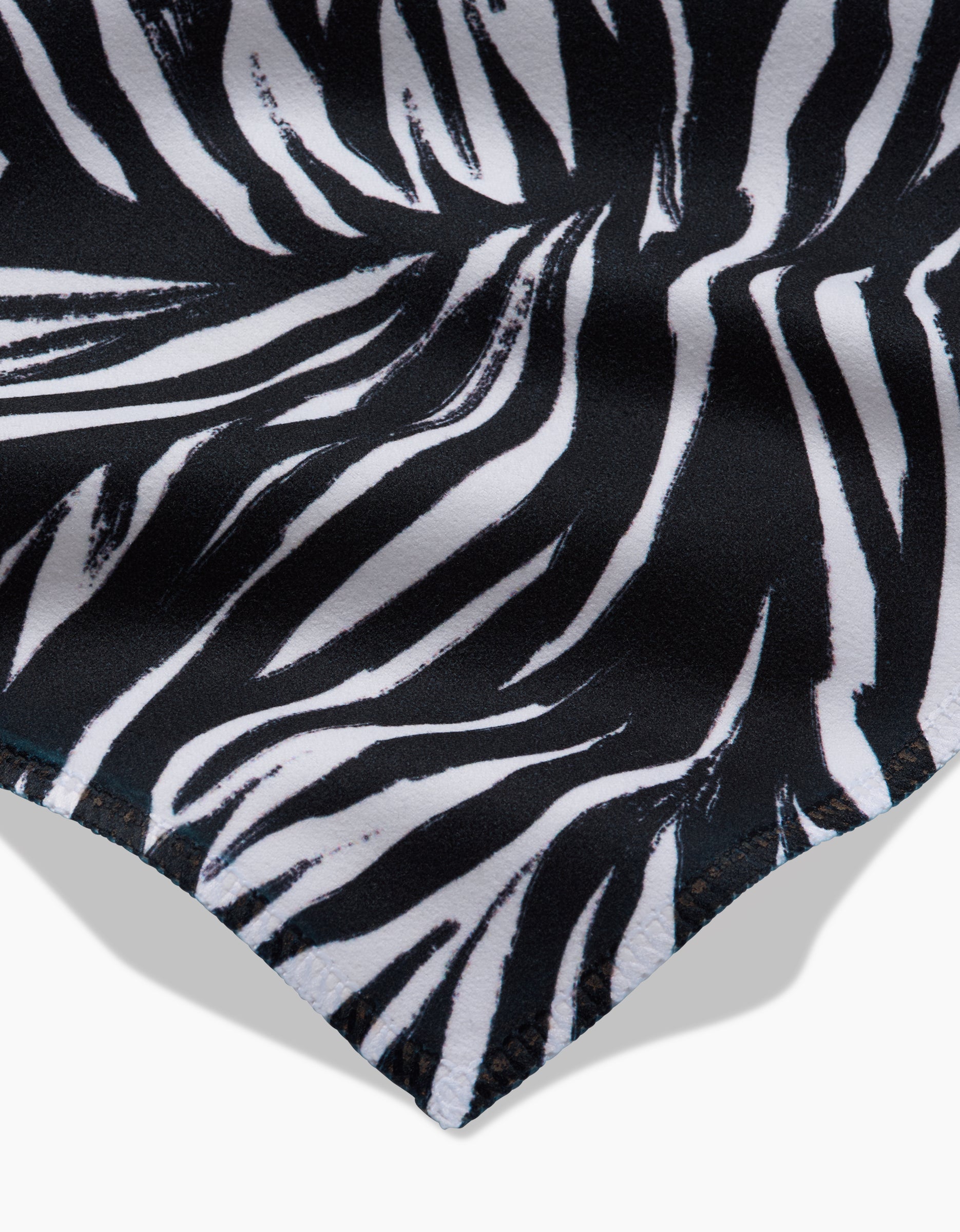 Close-up of Zebra by GEOMETRY, featuring a black and white zebra stripe pattern on soft Geosuede fabric, highlighting the materials flowing texture—ideal for stylish dinner napkins.