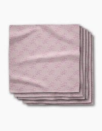 A stack of five Bubble Ditzy Dusty Rose reusable napkins by Geometry, featuring a subtle repeating pattern in dusty rose tones, is displayed folded on a white background.