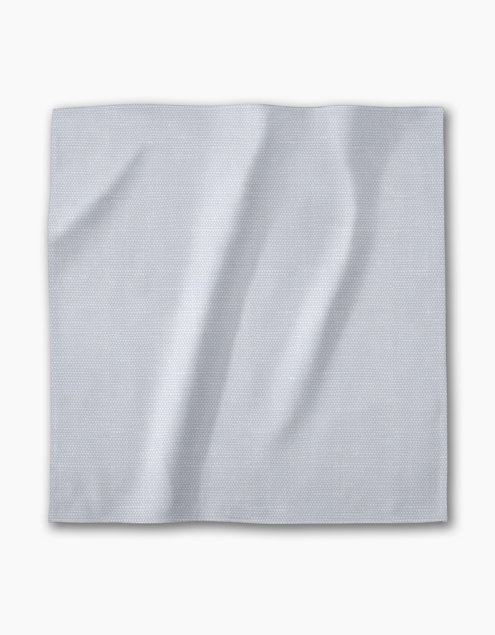 A Chambray Light Blue napkin from Geometry—a square, light gray-blue recycled fabric with a subtle textured pattern—lies flat on a white background. The absorbent cloth is part of an eco-friendly dinner napkin set.