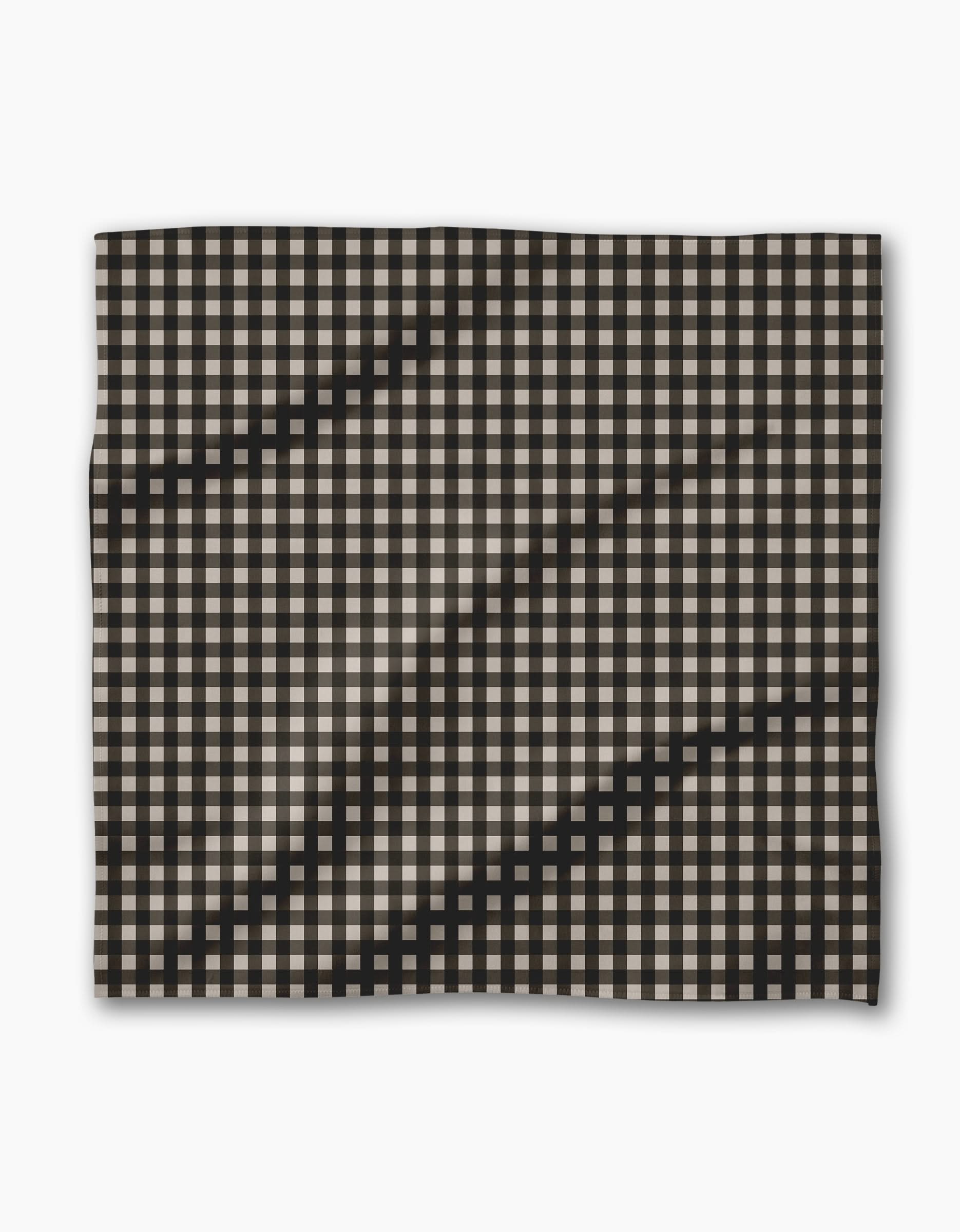 Geometry’s Charcoal Gingham features a black and white checkered fabric with visible waves and folds, set against a plain white background—perfect for your recycled Dinner Napkin Set.