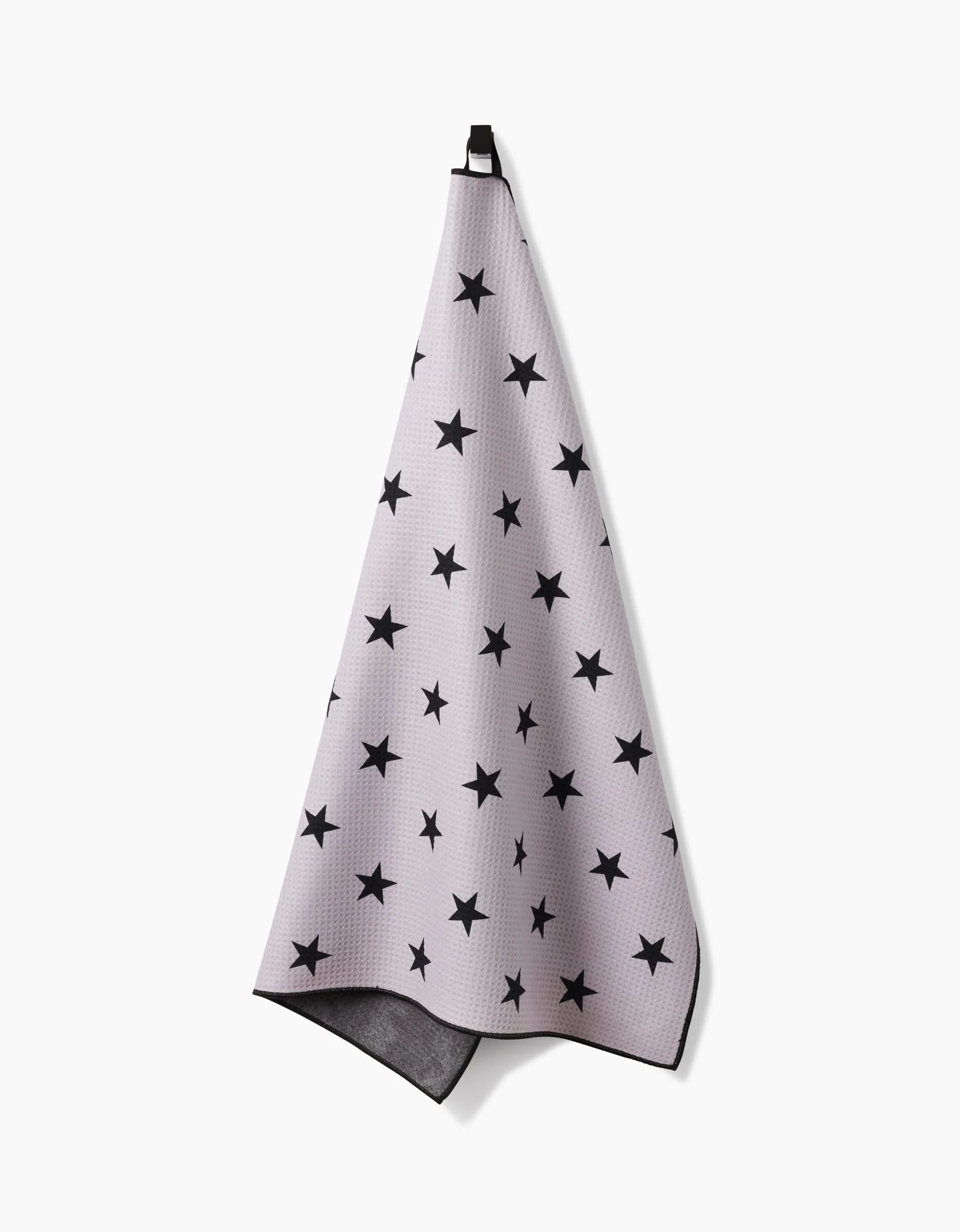 The Geometry Bark towel, in light gray with black stars and a black hanging loop, is highly absorbent and displayed against a white background.