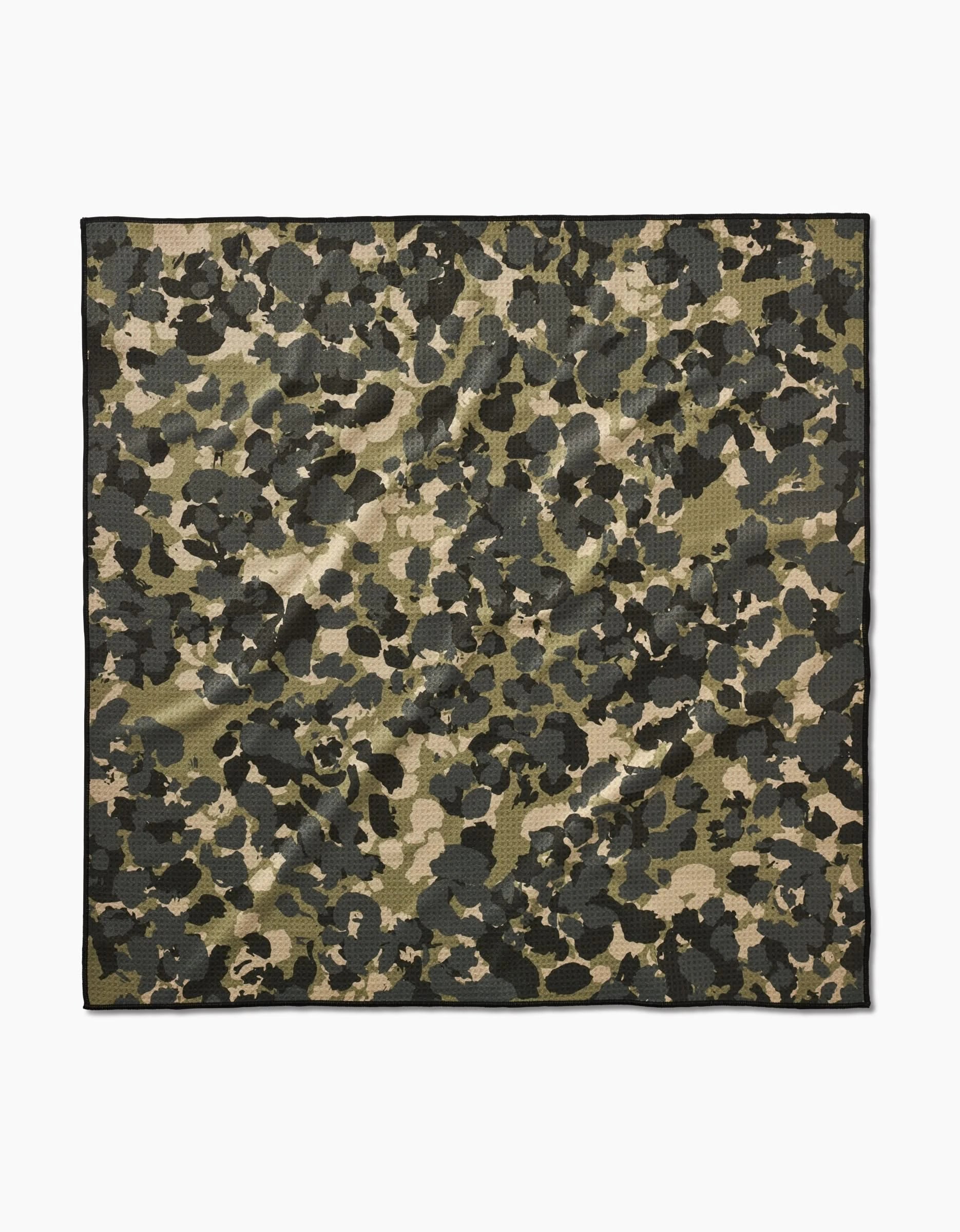 The Geometry Camo pet towel is a square, eco-friendly towel featuring a green, black, and beige camouflage pattern on a white background.