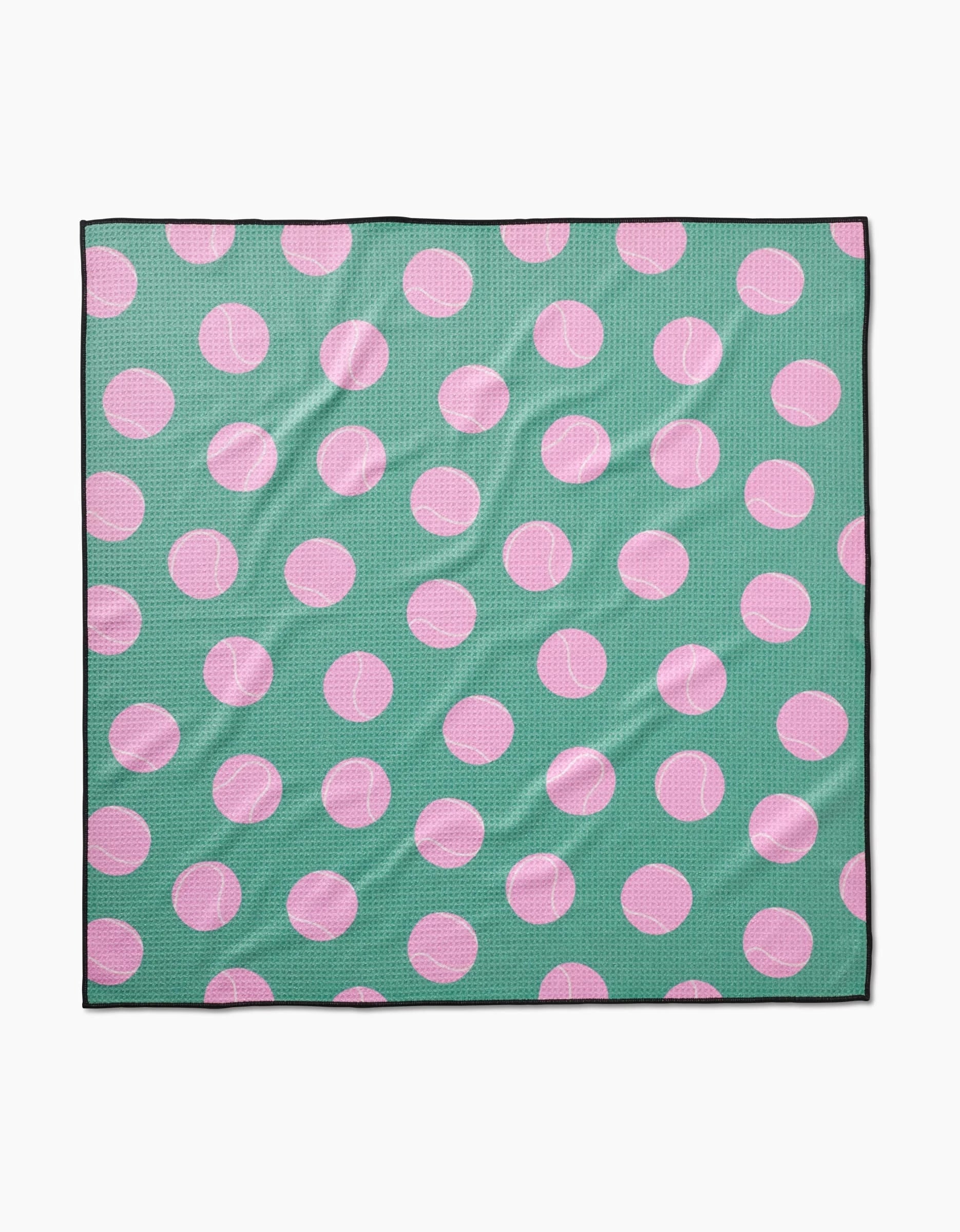 The Pink Ball dog towel by Geometry is a square, highly absorbent fabric towel made from recycled materials. It features a green background with large pink polka dots and a thin black border, and may appear slightly wrinkled.