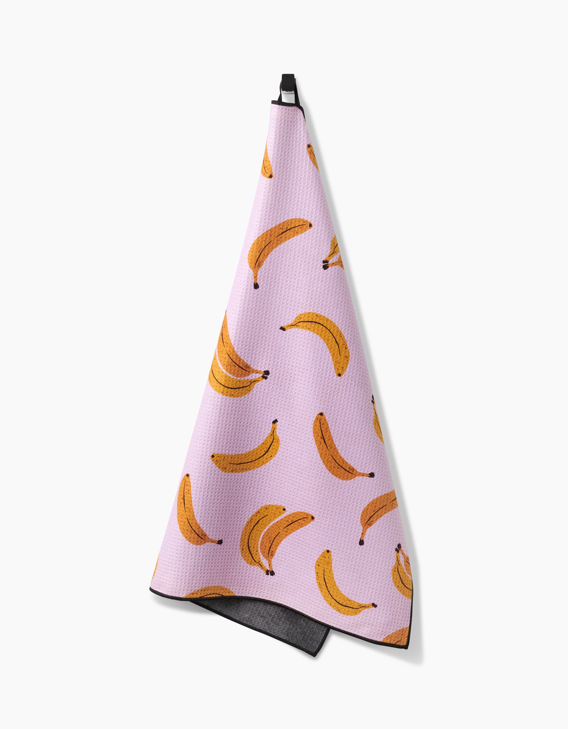 The Geometry Pupnana is a pink, highly absorbent dog towel featuring a repeating yellow banana pattern and a black hanging loop, shown against a white background.