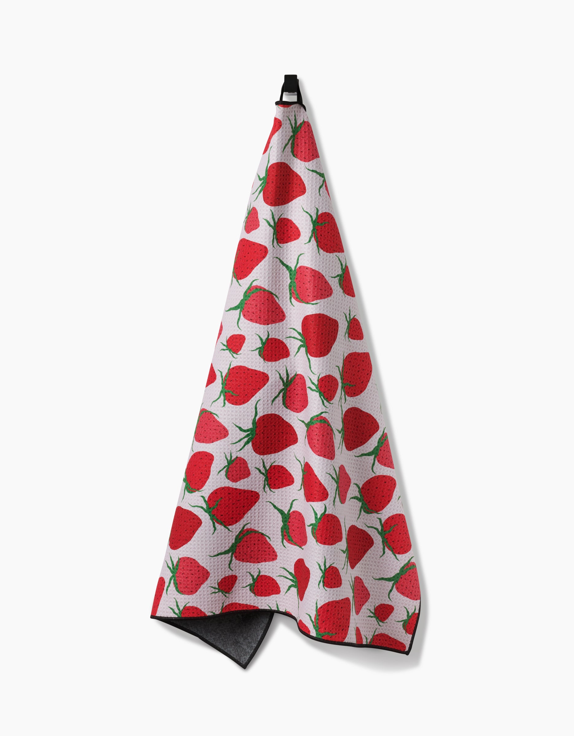 Geometry’s Strawberry Sniff is an eco-friendly, absorbent white kitchen towel featuring a bright red strawberry and green leaf pattern, displayed hanging from a black loop against a plain white background.
