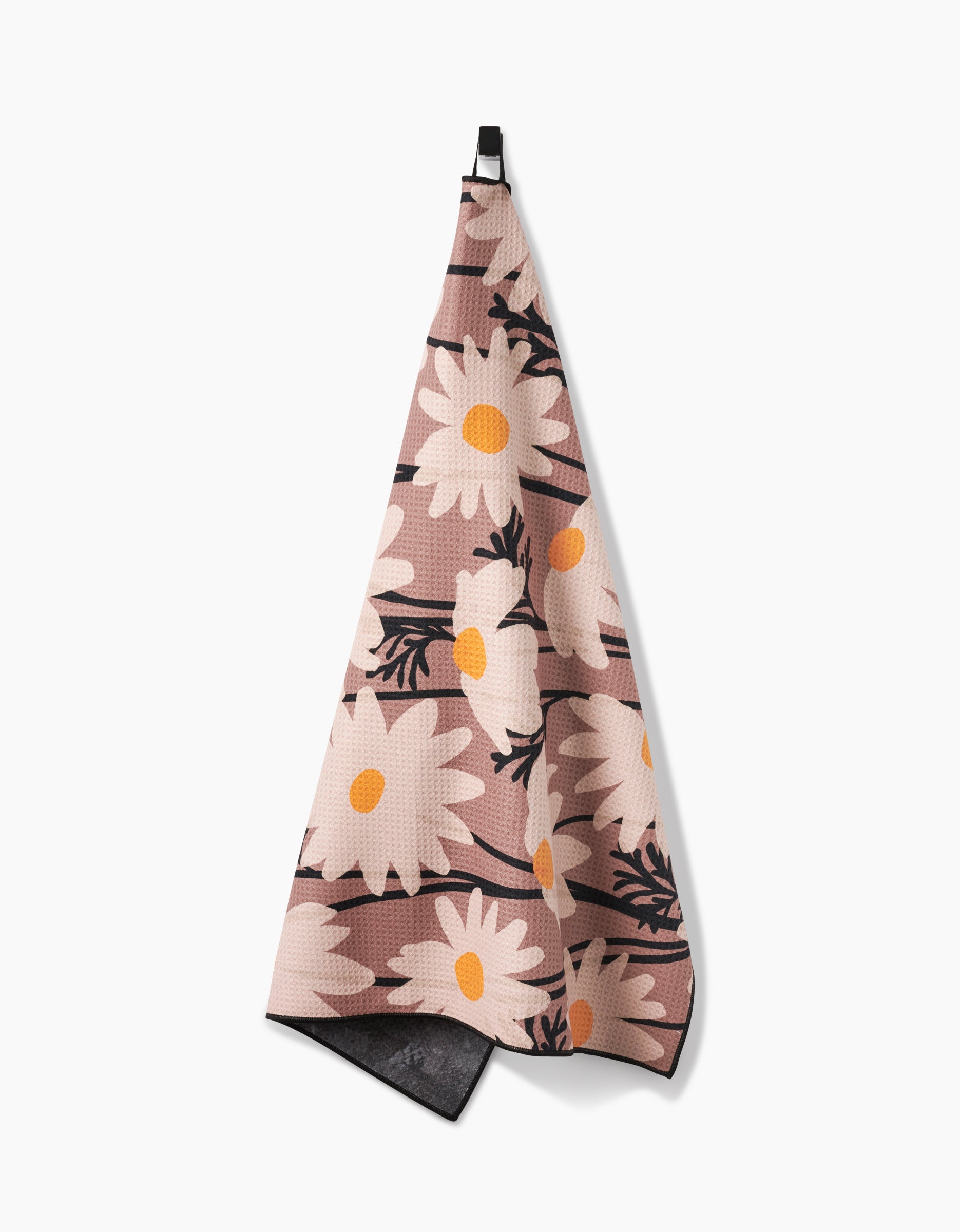 The Sweet Daisies hanging kitchen towel by Geometry features a pink background with large white daisies, yellow centers, and black stems—crafted from absorbent recycled materials.