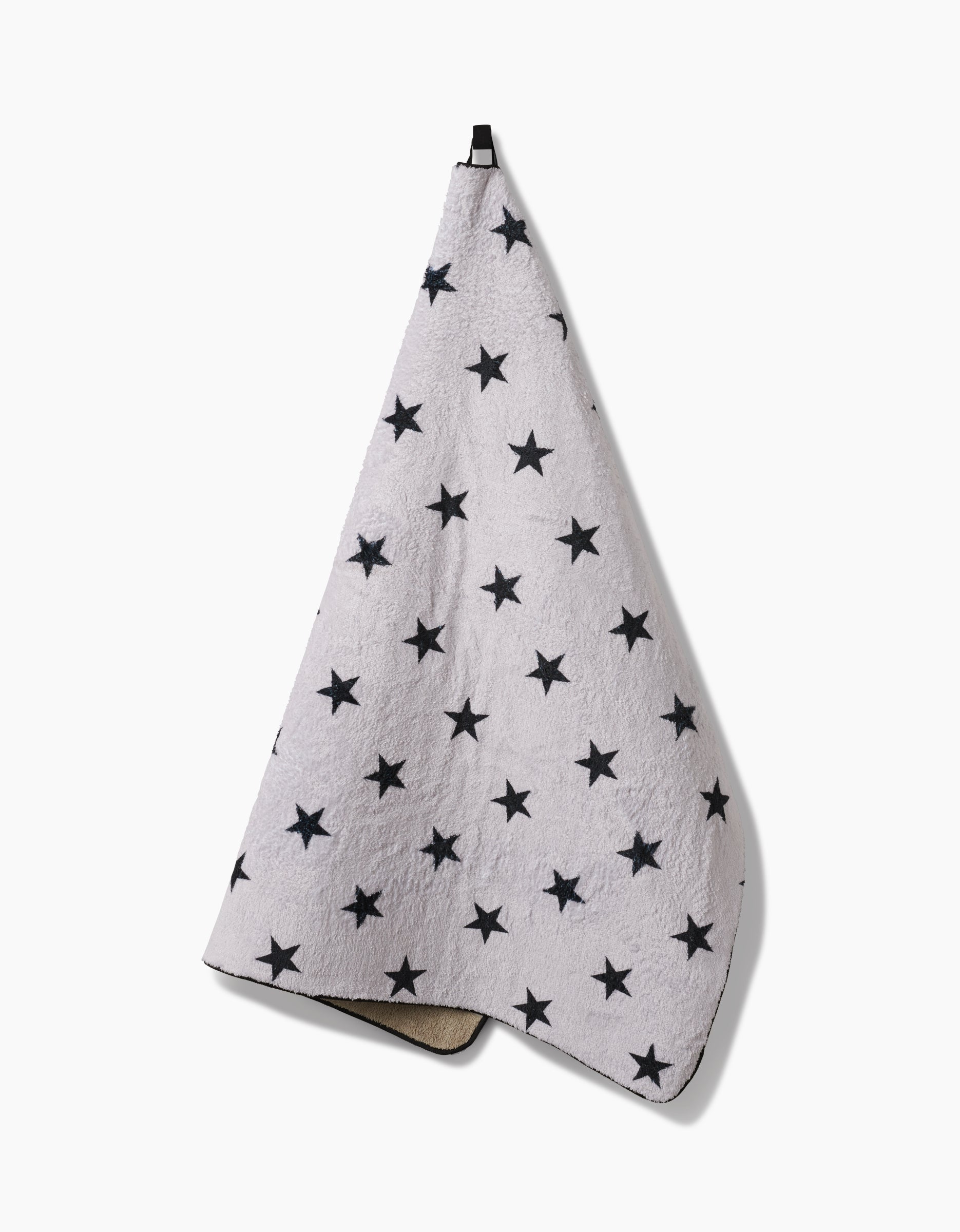 The Geometry Bark towel is ultra-absorbent and light gray with evenly spaced black stars, shown hanging from a black loop against a plain white background.