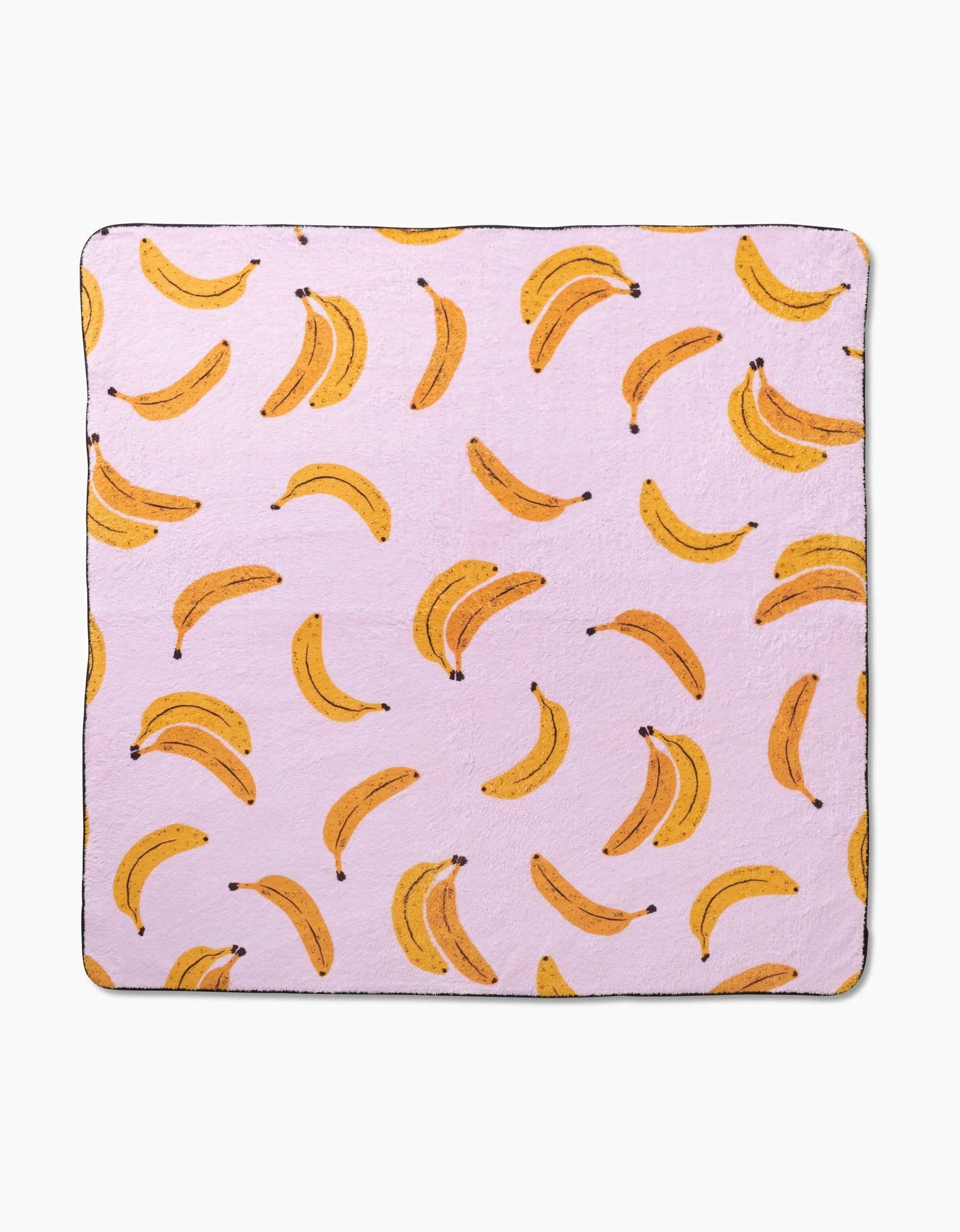Pupnana by Geometry is a luxurious dog towel crafted from recycled materials, featuring a light pink background with a playful yellow banana pattern.