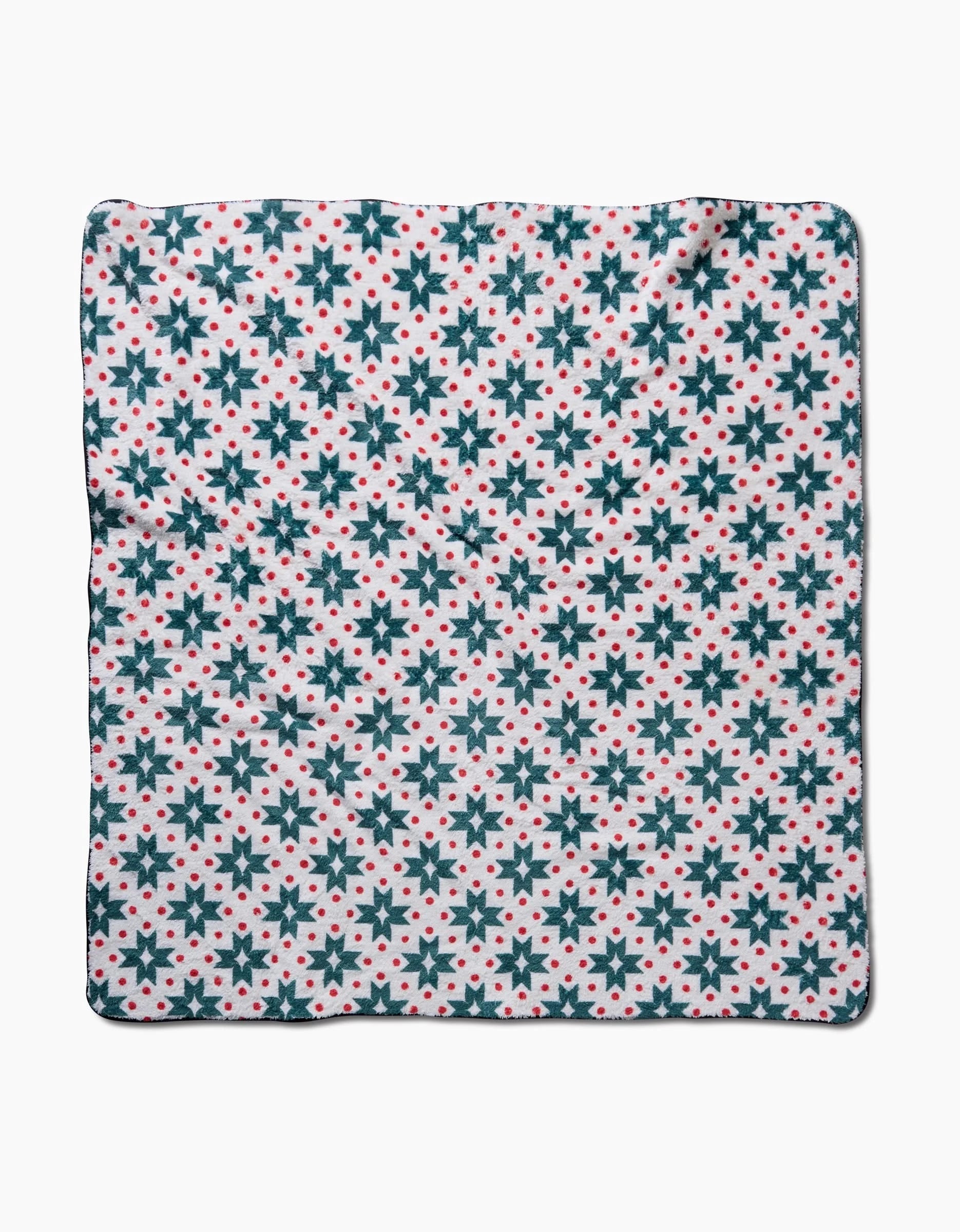 The Geo Star dog towel by Charlie Rowan Designs features a square shape with dark blue snowflakes and red dots on white. Ultra-absorbent and stylish, it delivers exceptional drying power for your pup.