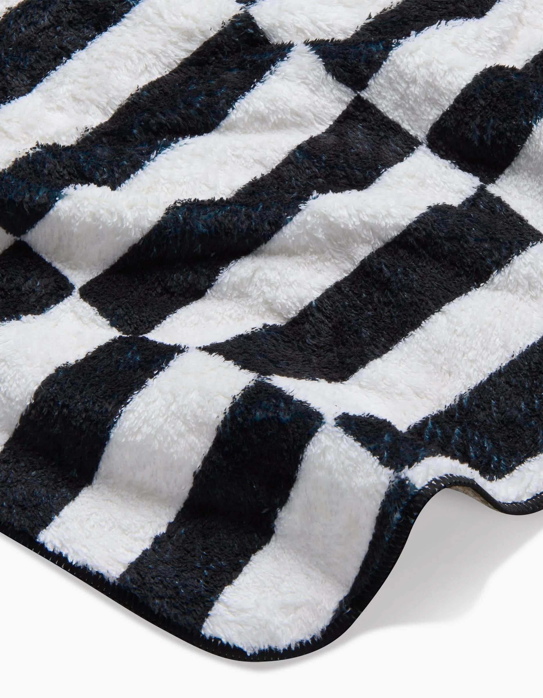 A close-up of Long Check, the ultra-absorbent plush dog towel by Hufton Studio, featuring soft recycled fabric with a black and white wavy check pattern for a cozy, eco-friendly touch.