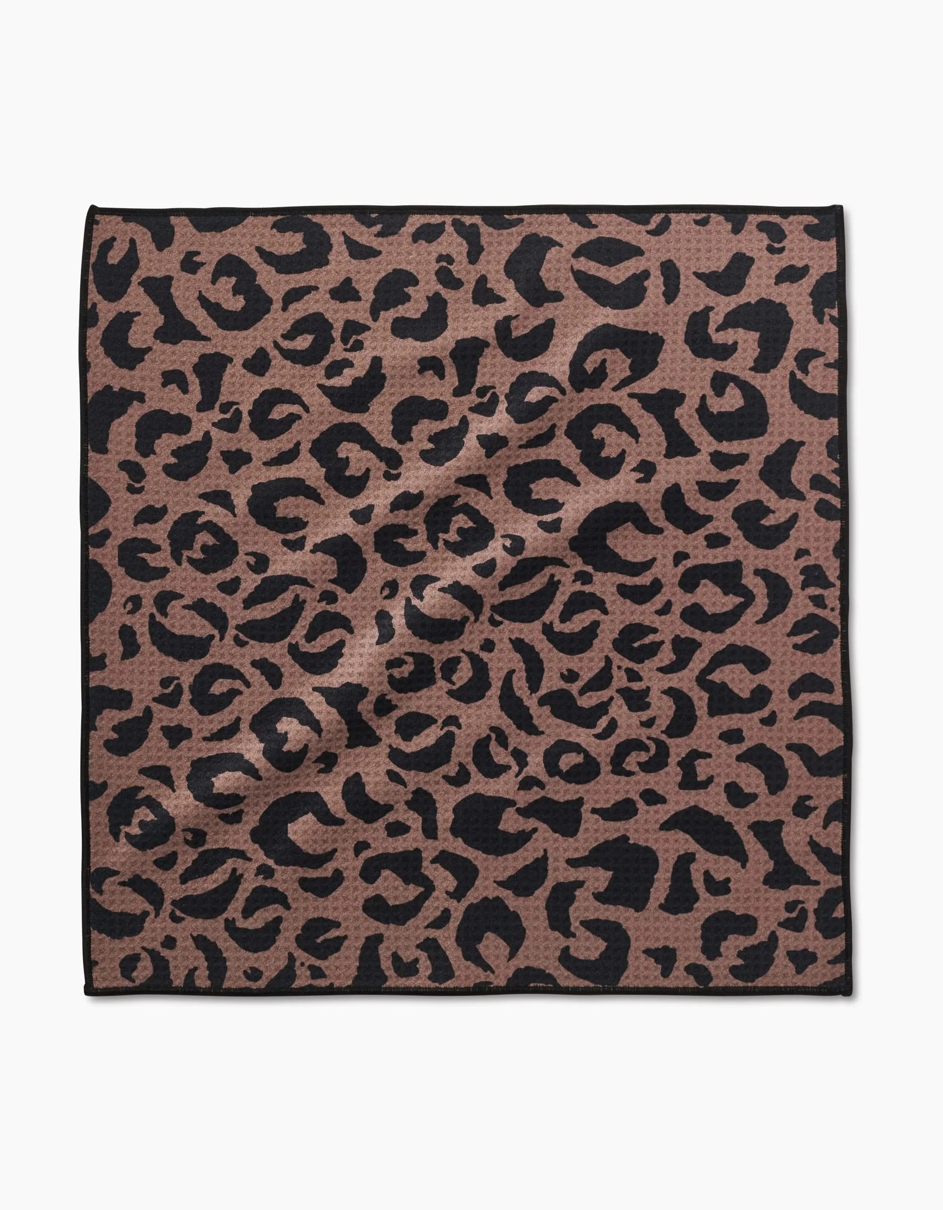 The Cheetah Hound Paw Towel by Geometry is a square towel made from ultra-absorbent Geoweave™ fabric, featuring a brown background with a black leopard print and a thin black border.