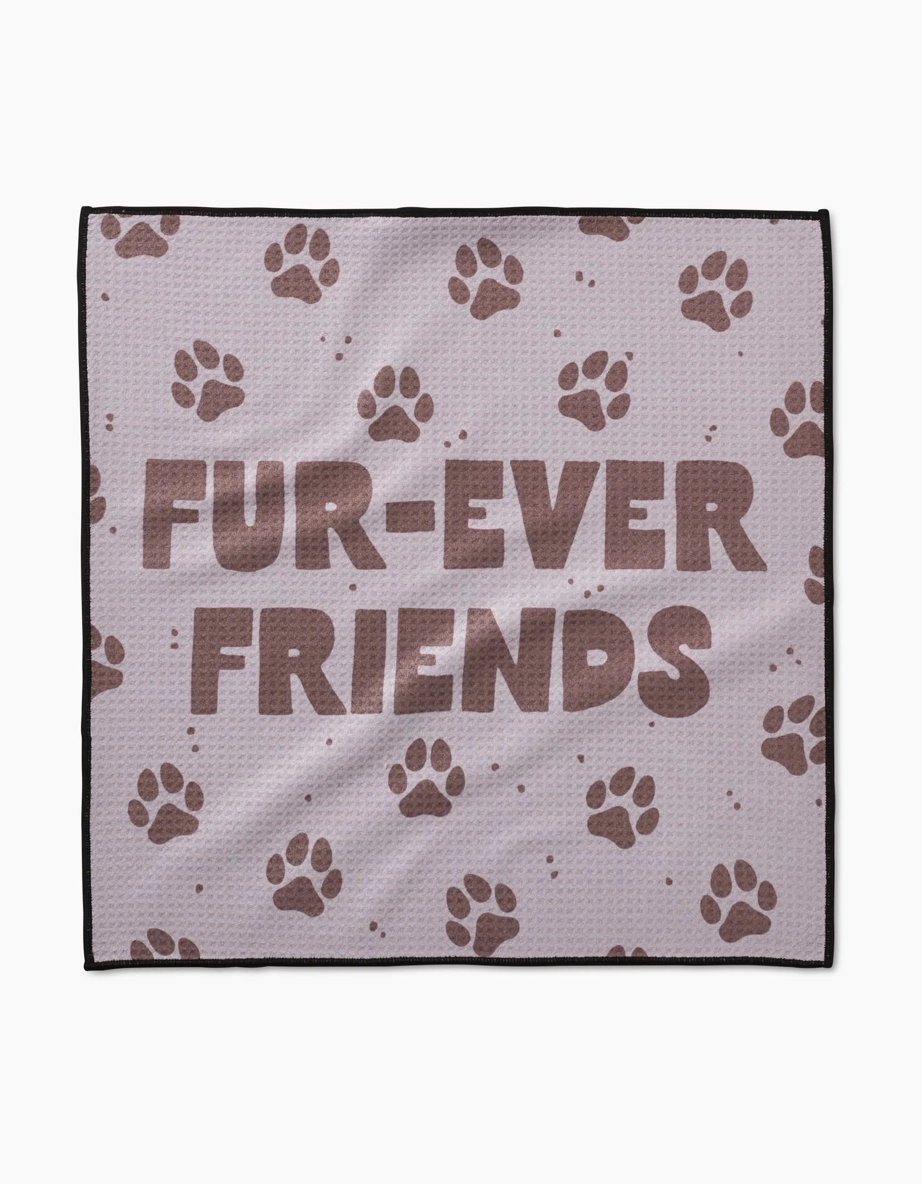The Geometry Fur Ever Friends blanket is light purple, crafted from ultra-absorbent Geoweave fabric, and displays FUR-EVER FRIENDS in bold brown letters with scattered brown paw prints.