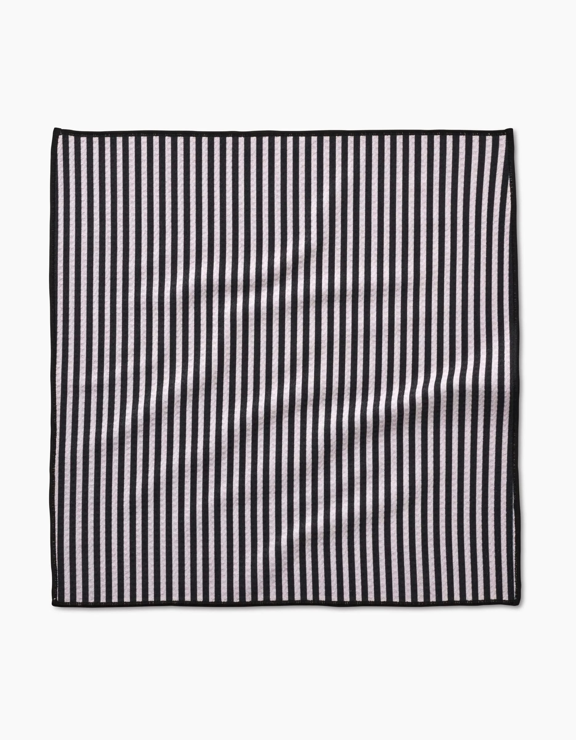 The Geometry Good Pup rectangular Paw Towel features vertical black and white stripes, a thin black border, and is made from ultra-absorbent recycled materials, shown on a plain white background.