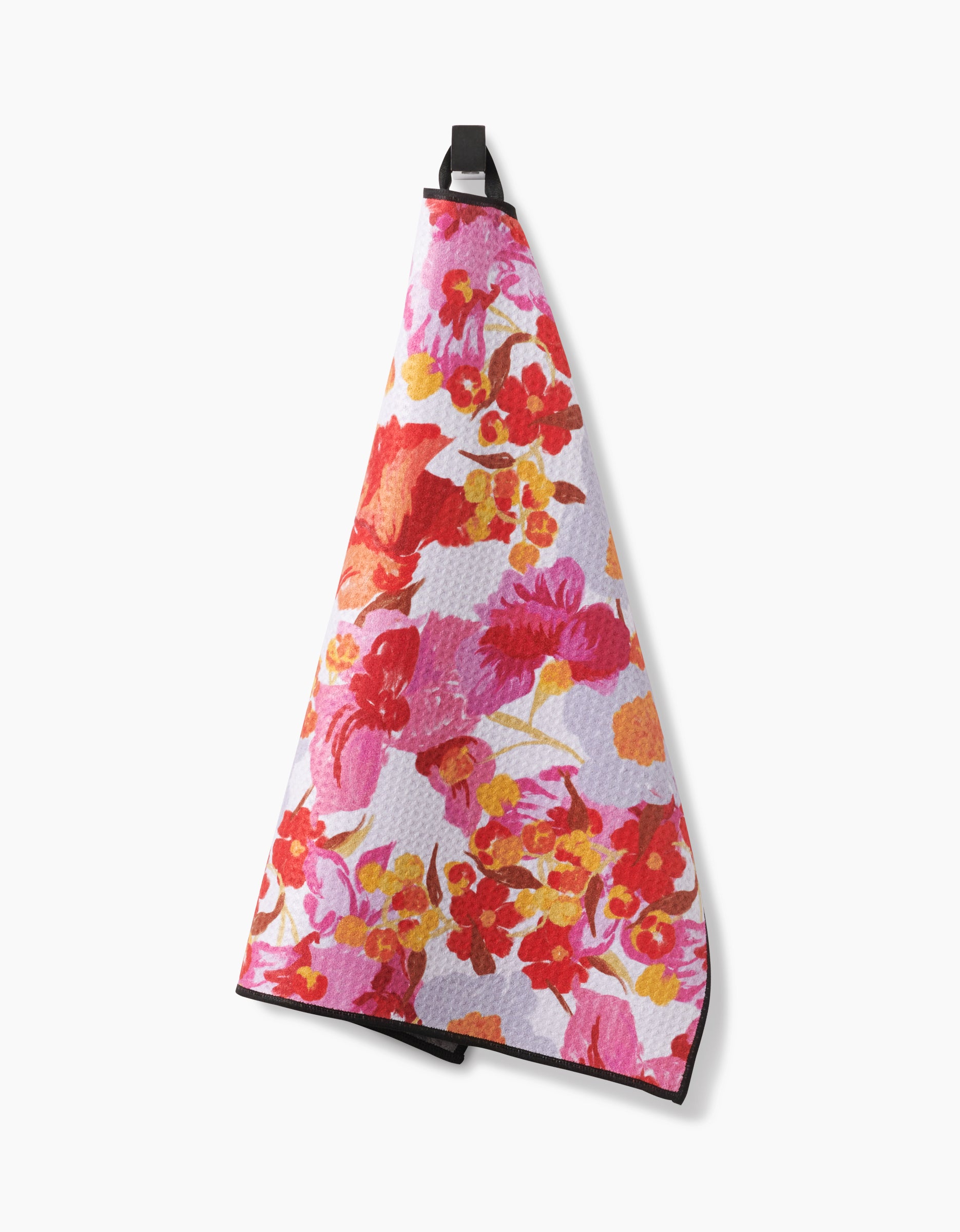 A Geometry Pup Florals Paw Towel, featuring a vibrant floral pattern in red, pink, orange, and yellow, hangs from a black loop. Made from ultra-absorbent Geoweave fabric for quick drying and exceptional softness.