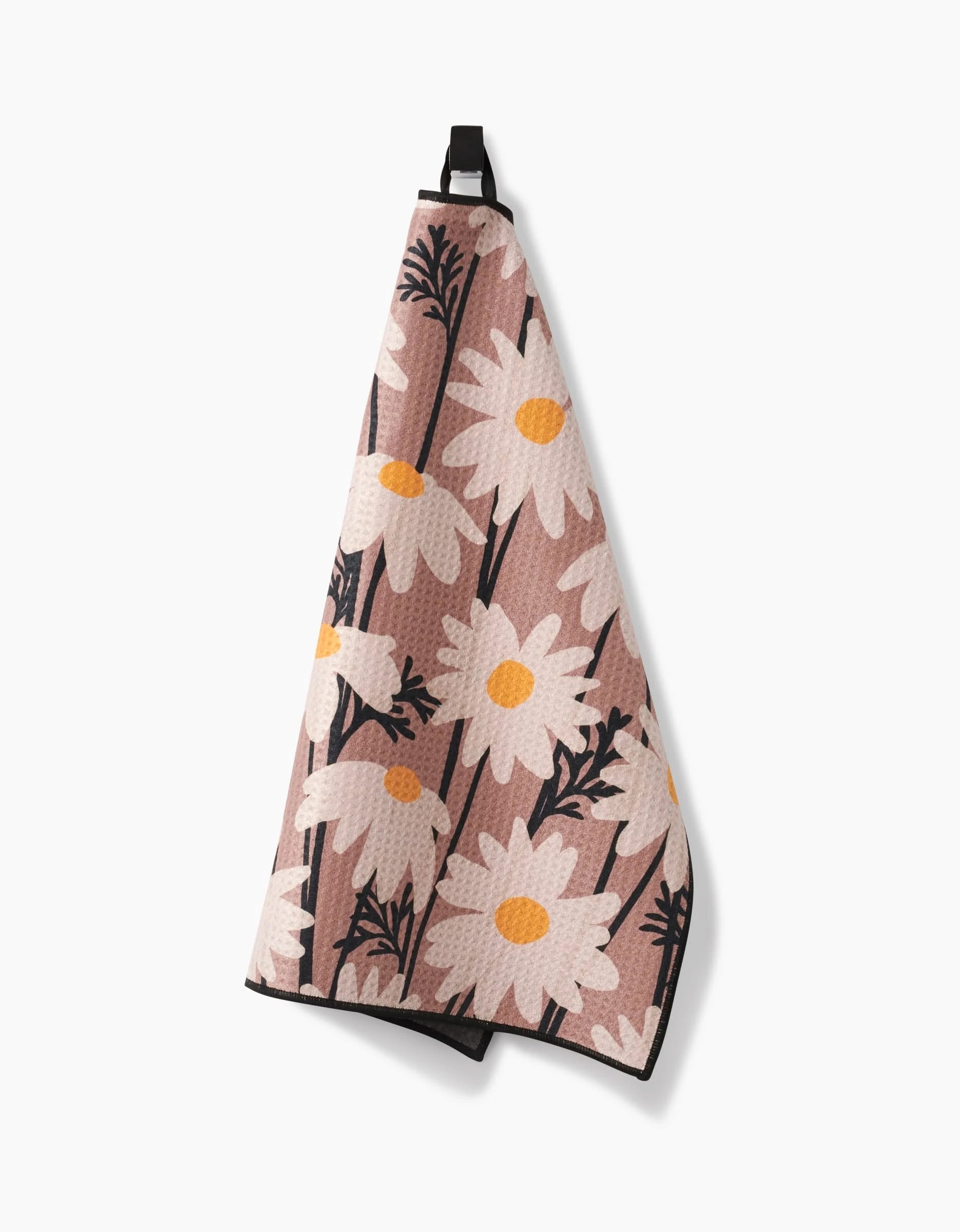 The Geometry Sweet Daisies kitchen towel, made with ultra-absorbent Geoweave fabric, features large white daisies with yellow centers and black stems on a pink background, and includes a black hanging loop.